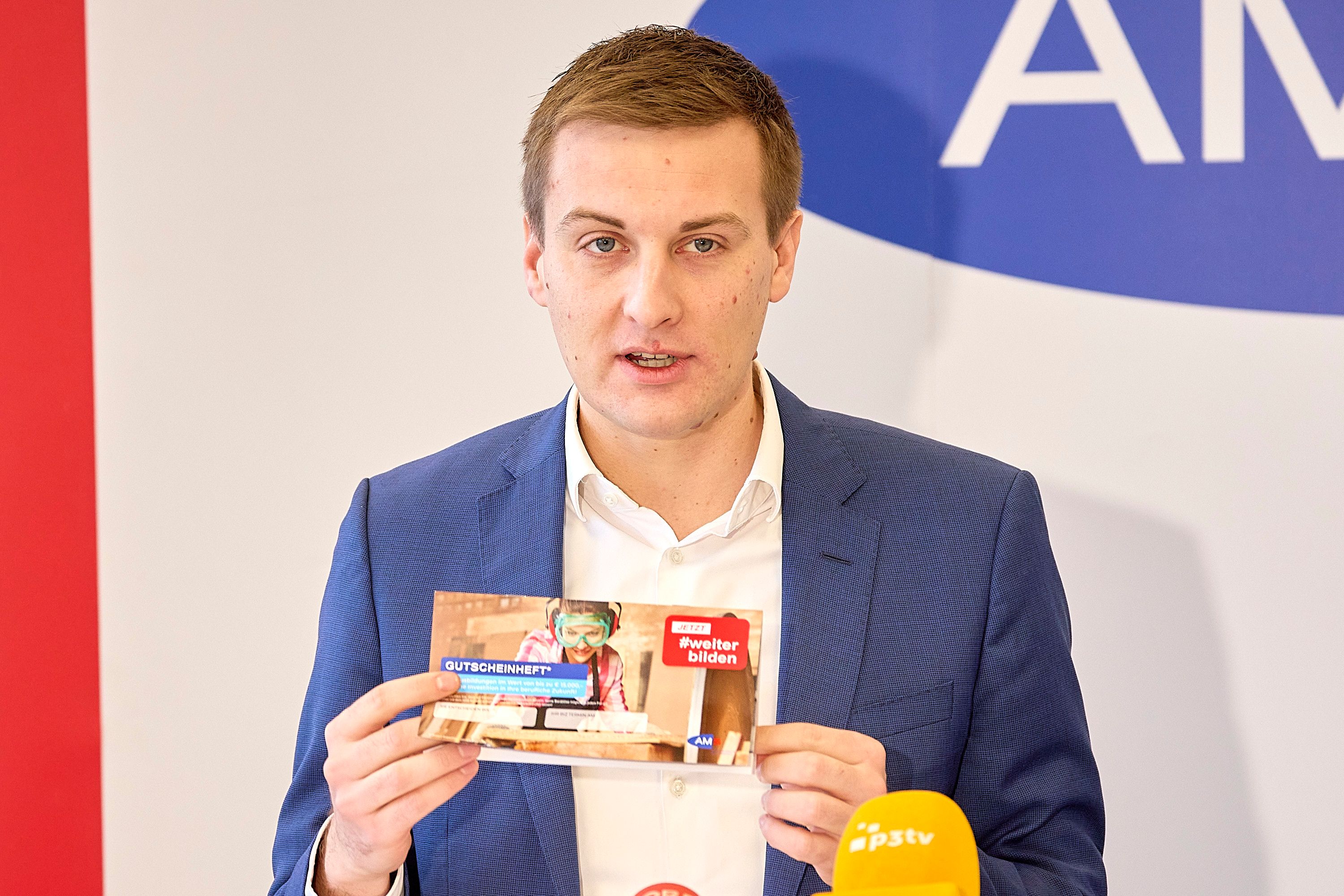 Sven Hergovich (Landesgeschäftsführer AMS NÖ) mit dem Gutscheinheft.