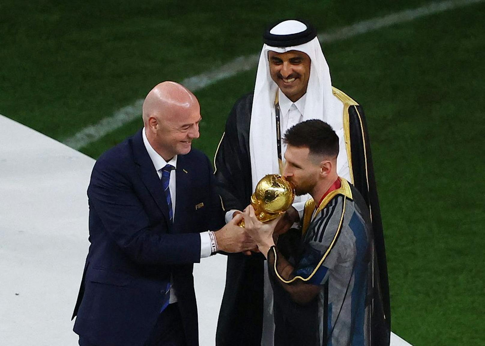 Lionel Messi mit Umhang und dem Kuss für den Pokal.