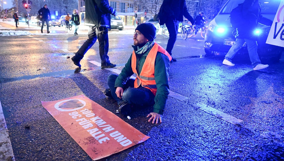 Ein Klima-Kleber der Letzten Generation hat sich auf der Fahrbahn festgeklebt, um gegen die Klimapolitik zu protestieren.