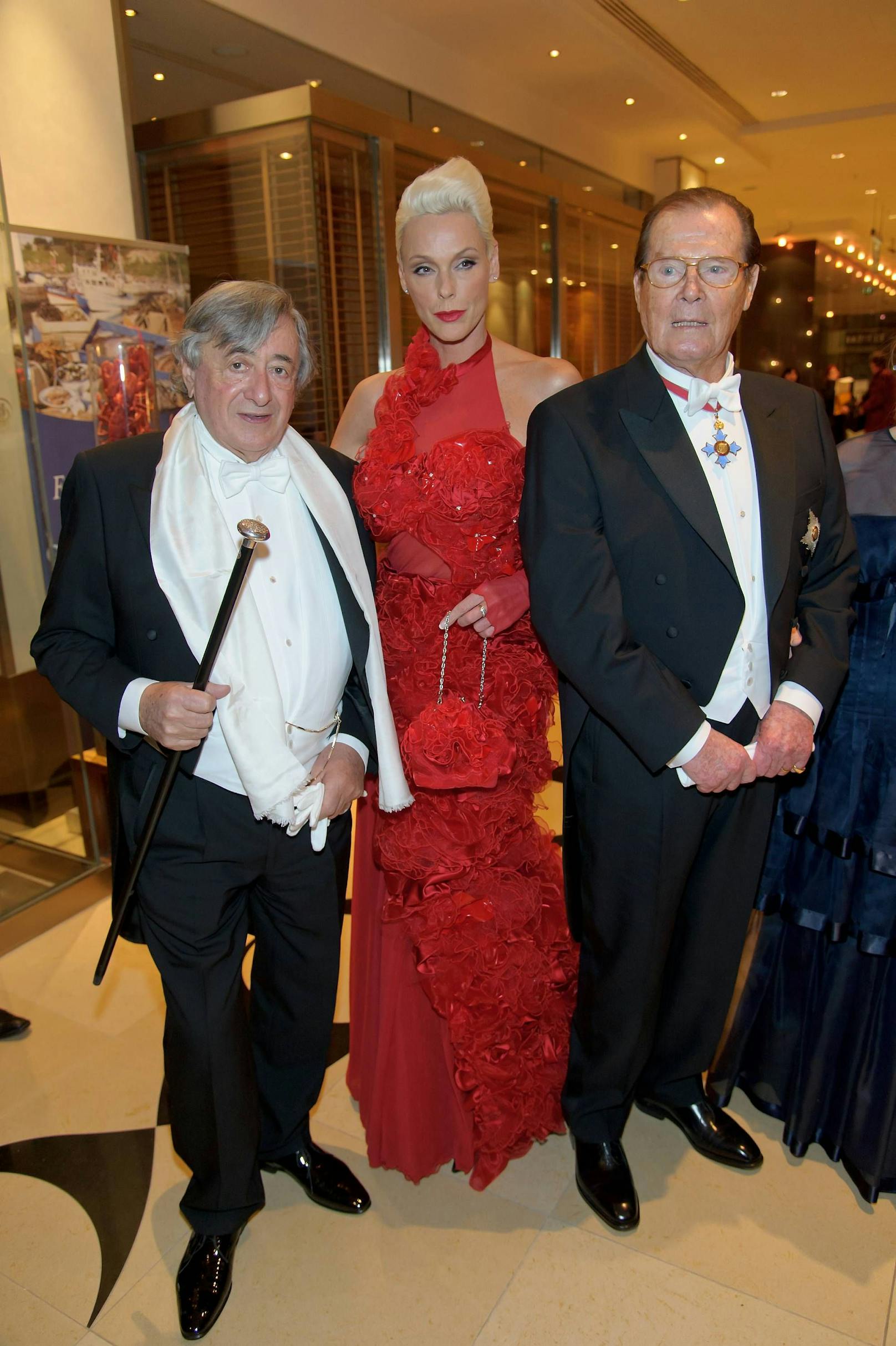2012: Brigitte Nielsen und Roger Moore nehmen in Lugners Loge Platz.