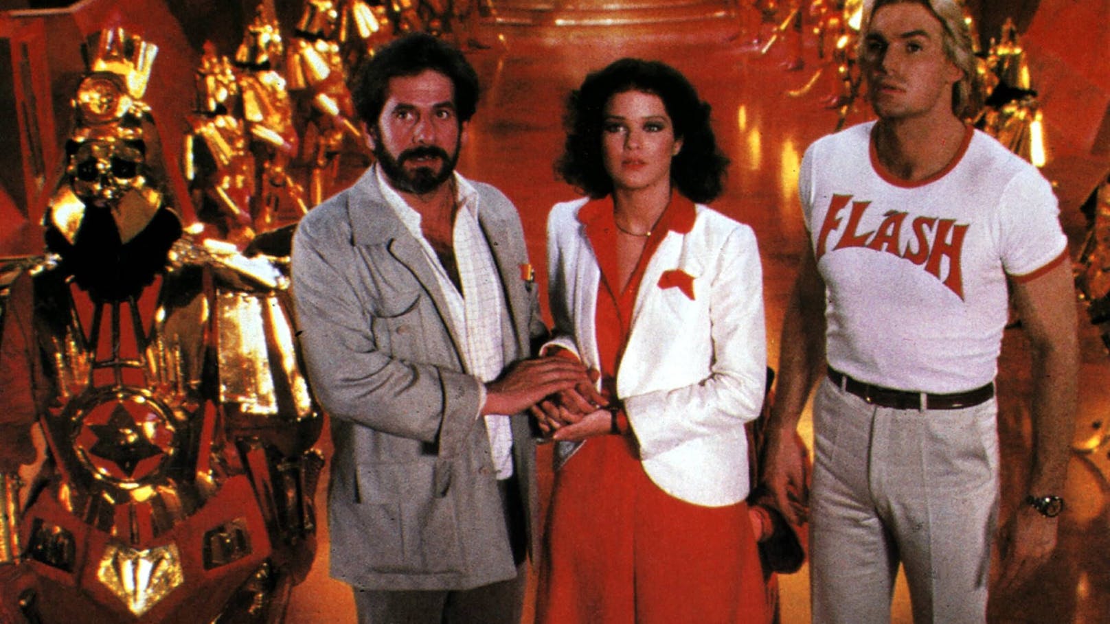 Regisseur Mike Hodges mit den Schauspielerin Melody Anderson und "Flash Gordon" Sam J. Jones (1980)