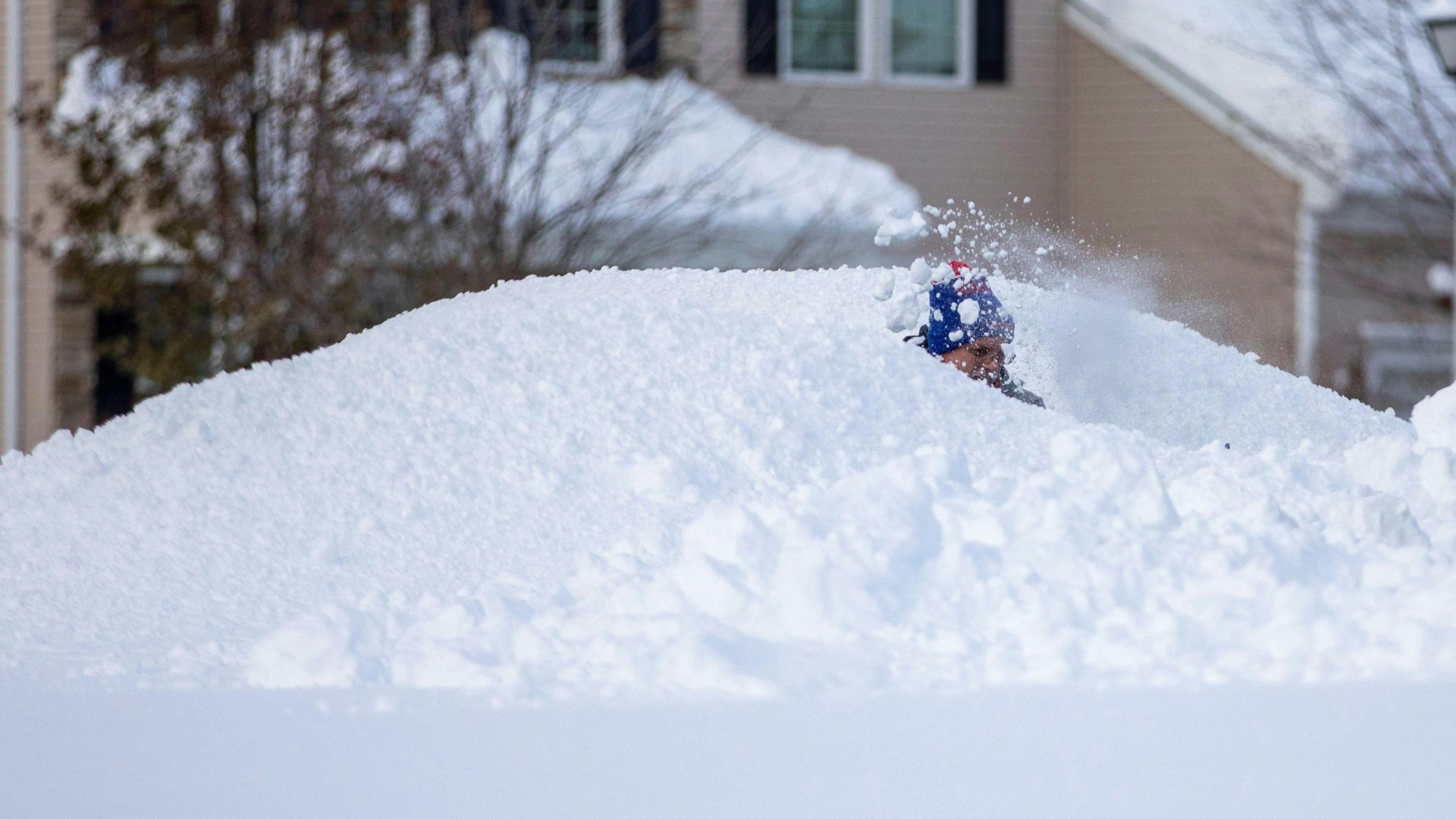 A man shovels snow during a break in the snow storm hitting the Buffalo area, in Orchard Park, New York, U.S. November 19, 2022 REUTERS/Carlos Osorio