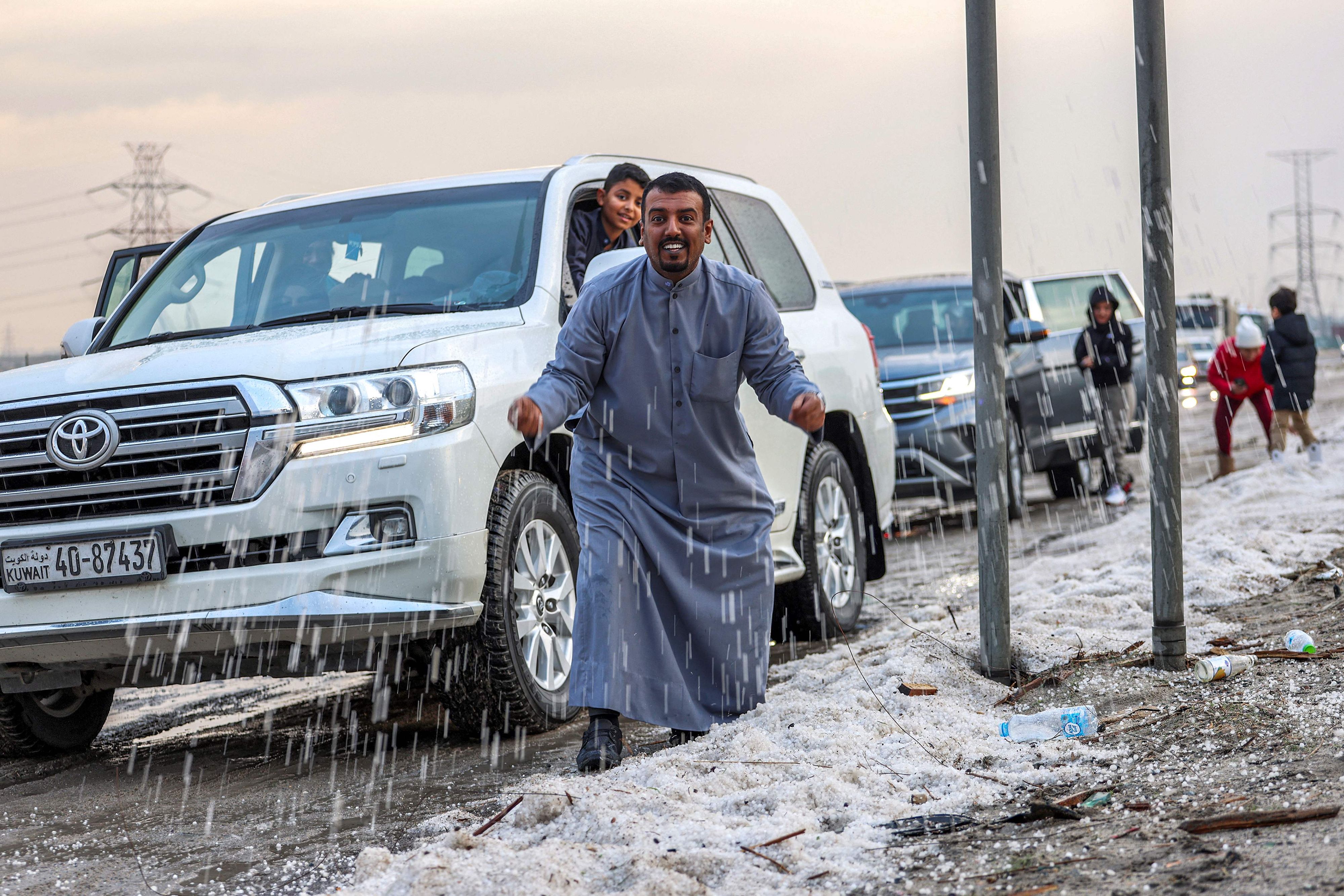 Download von www.picturedesk.com am 28.12.2022 (14:29).  People inspect hail particles lying on the side of a road after a storm in the Umm al-Haiman district, about 55 kilometres south of Kuwait City, on December 27, 2022. (Photo by YASSER AL-ZAYYAT / AFP) - 20221227_PD3506 - Rechteinfo: Rights Managed (RM) Nur für redaktionelle Nutzung! Werbliche Nutzung erfordert Freigabe: bitte schicken Sie uns eine Anfrage.