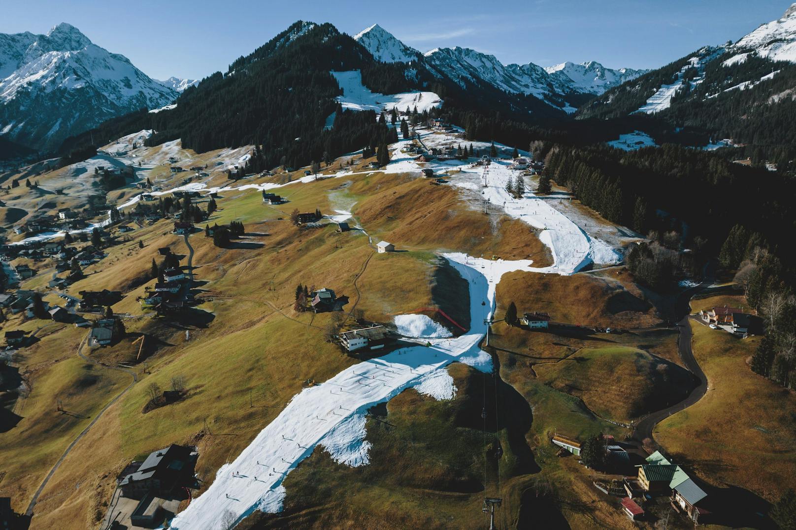 In Riezlern (Vorarlberg) durchzieht ein weißer Streifen die grüne Landschaft.