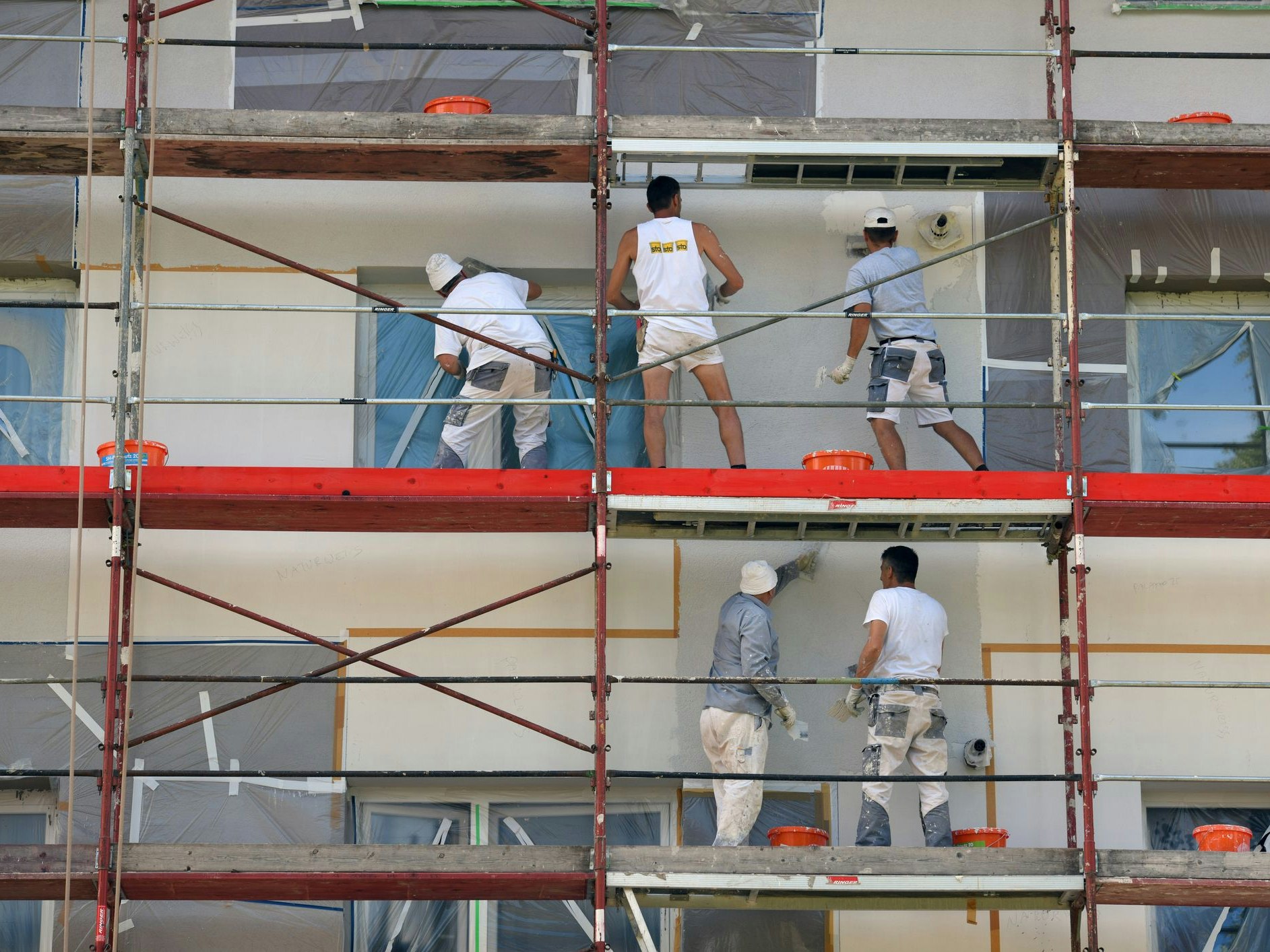 Scaffolding with workers during the thermal renovation of a house facade in Austria, Europe
