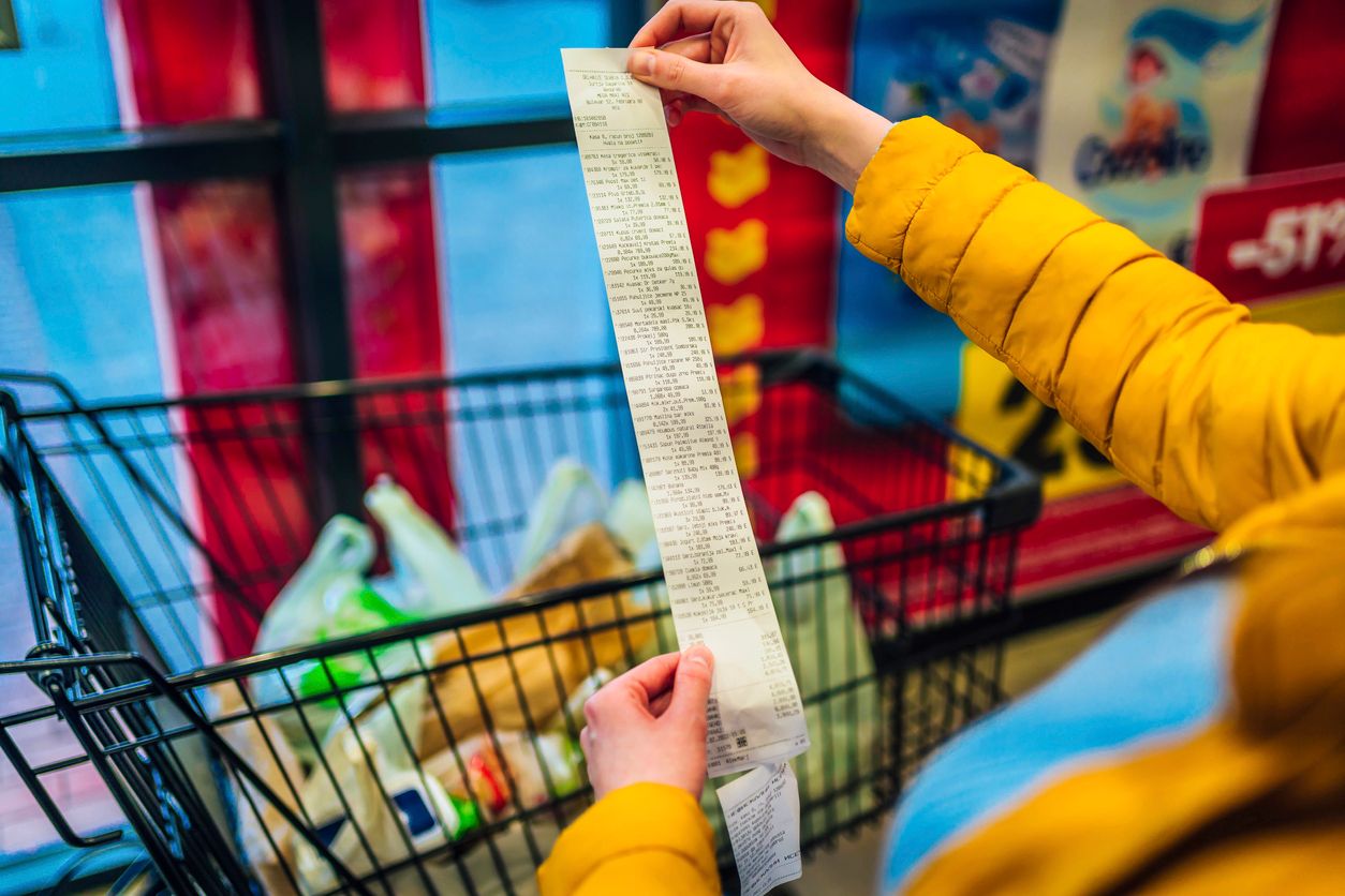 Woman looking receipt from a supermarket