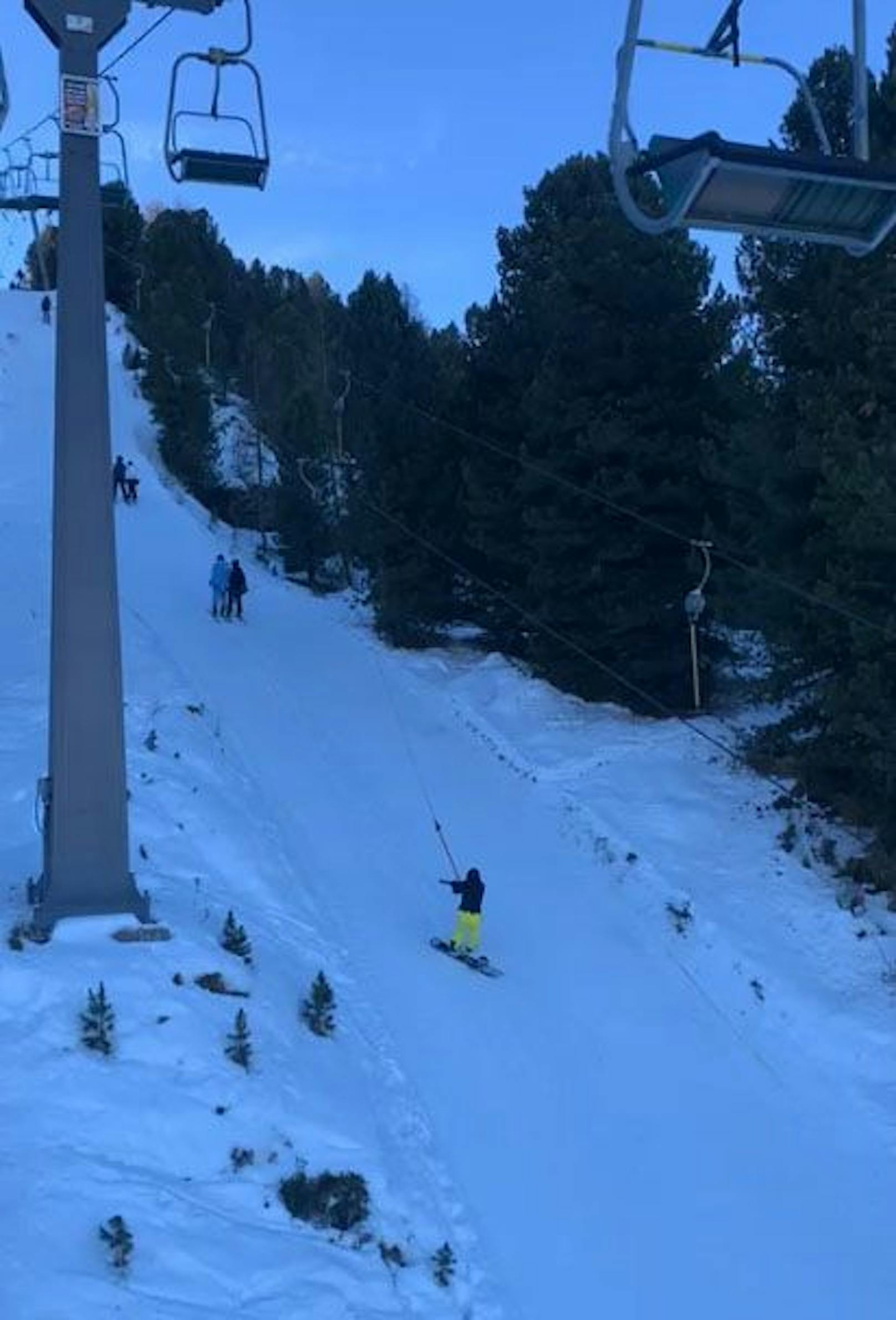 Ein Skifahrer filmt die Szene gemütlich aus einem Sessellift.