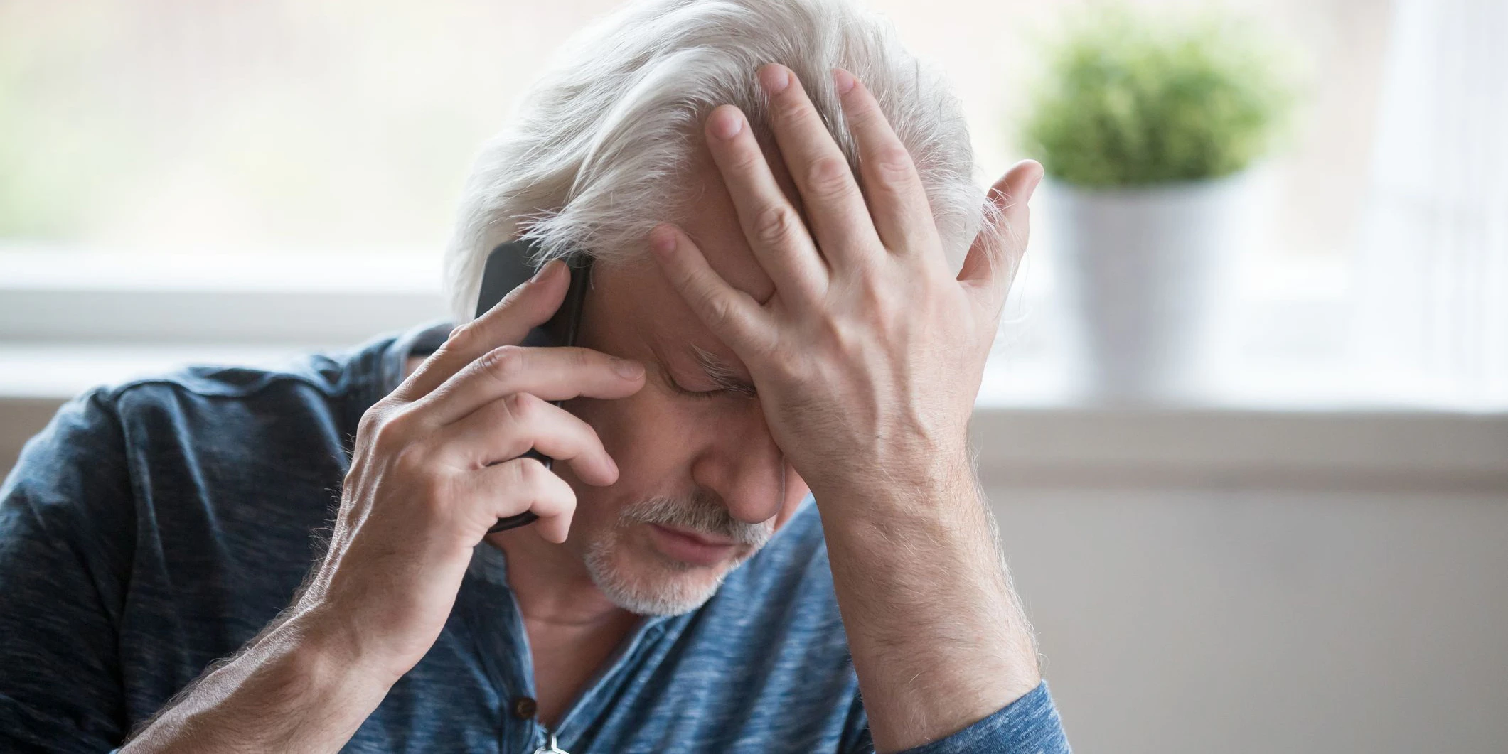 Frustrated older mature retired man feeling upset desperate talking on the phone having problems debt, stressed sad middle aged male depressed by hearing bad news during mobile conversation at home