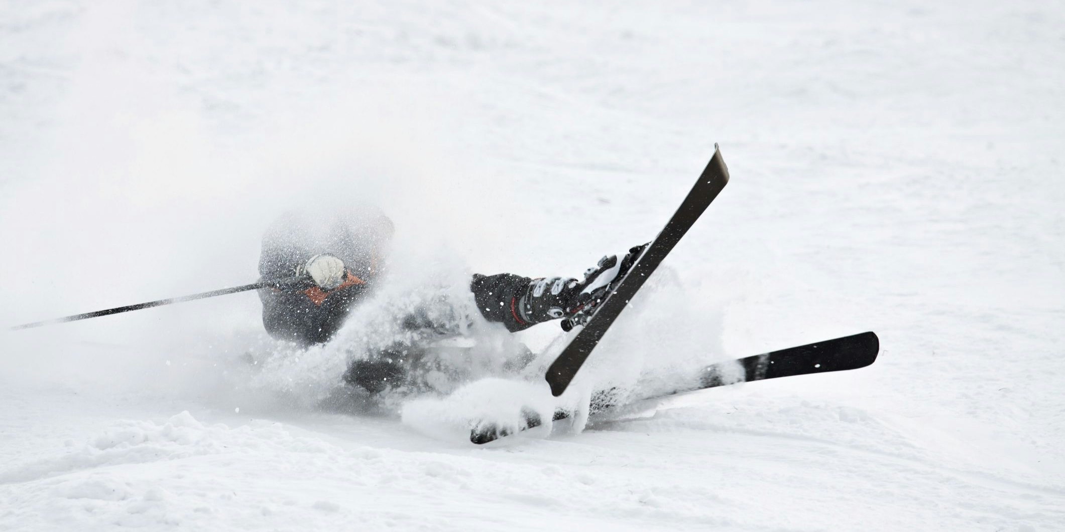 Man riding on skis fall down, he could break something.