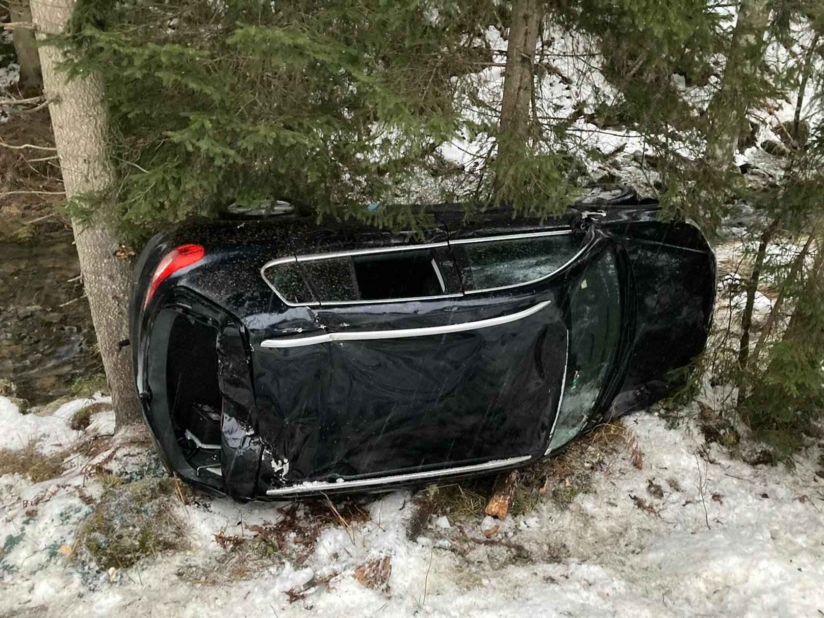 Der Pkw stürzte über eine Böschung, überschlug sich mehrmals und blieb nach ca. 25 Meter an Bäumen hängen.