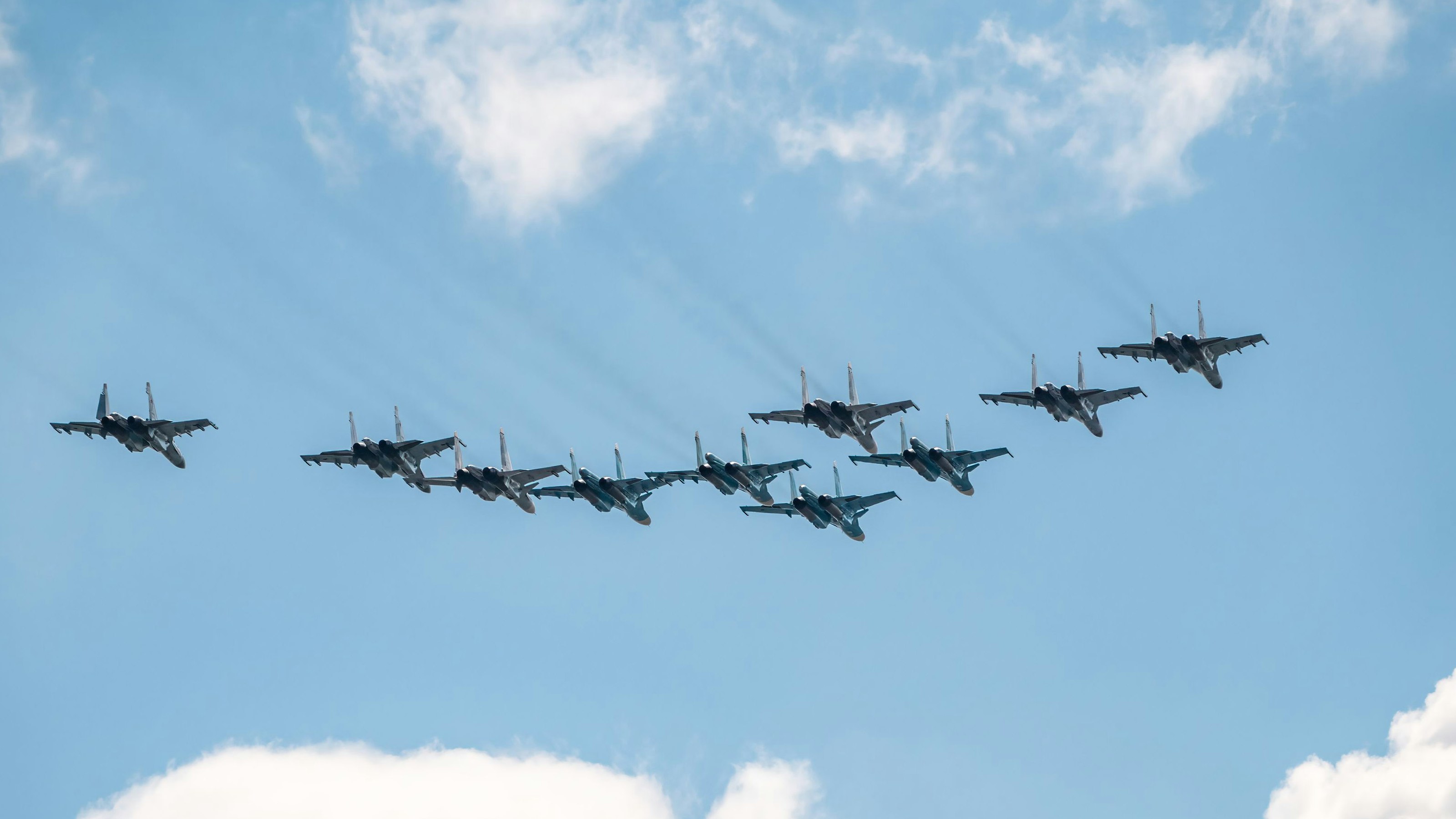 Die Kämpfer Su-35S und Su-30SM mit Bombern Su-34 am blauen Himmel über dem Roten Platz in Moskau. Archivbild vom 5. Mai 2021.