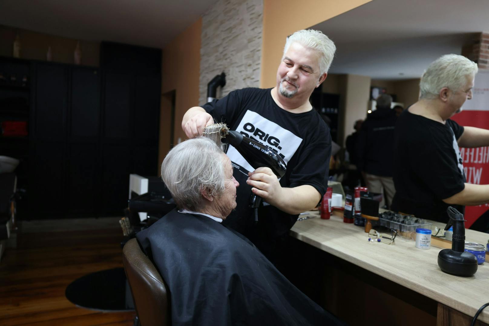 Friseur Neša schneidet für eine Aktion gratis die Haare von Kundin Annemarie.