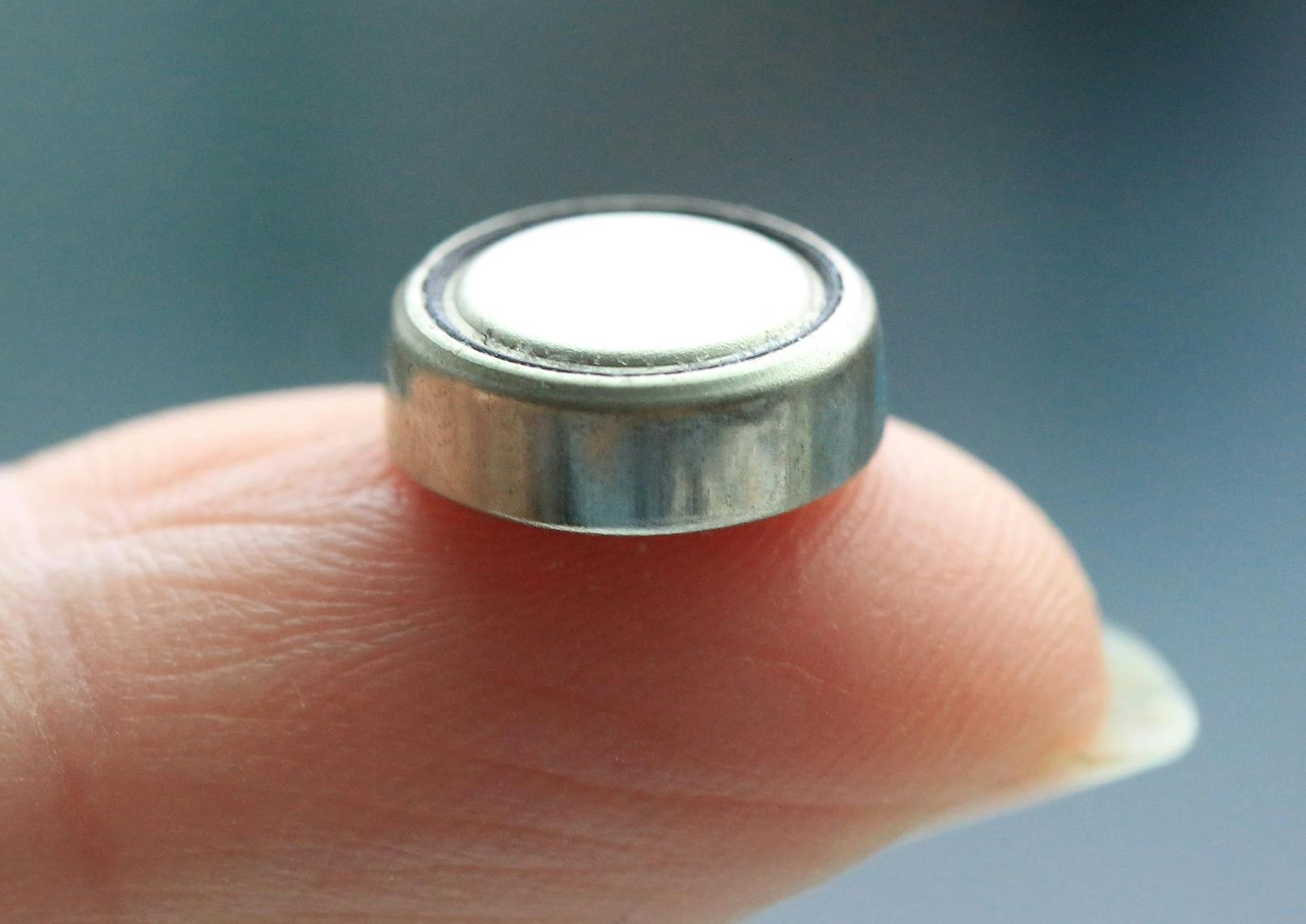 Selbst winzige Knopfzellen wie diese können für Kinder zur Gefahr werden.