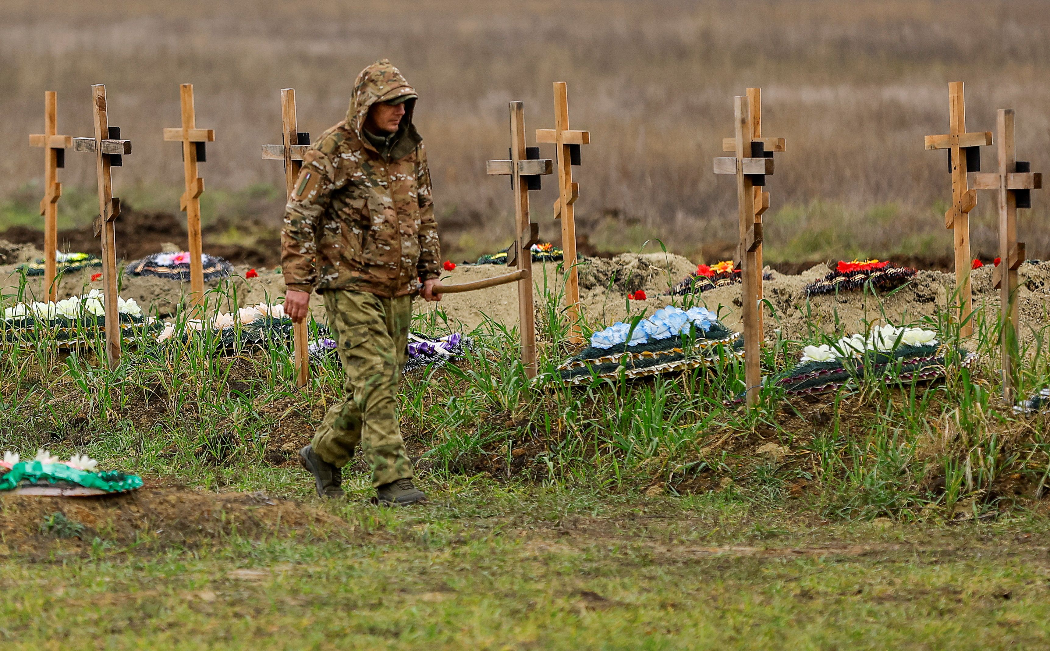 Ein Totengräber vor den frischen Gräbern pro-russischer Separatisten in Luhansk, aufgenommen am 11. November 2022.