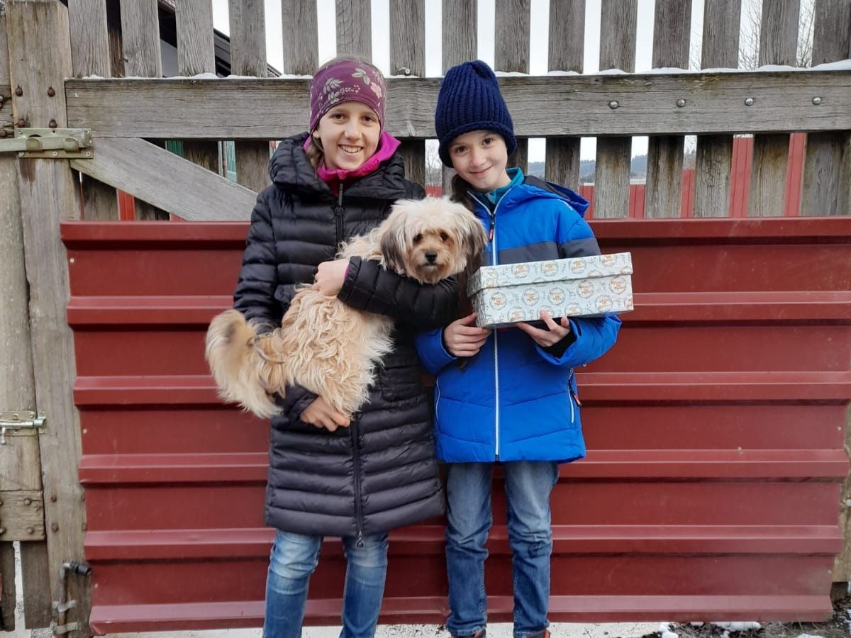 Flöckchen posiert mit den beiden Mädchen und ihrem neuen Rollstuhl.