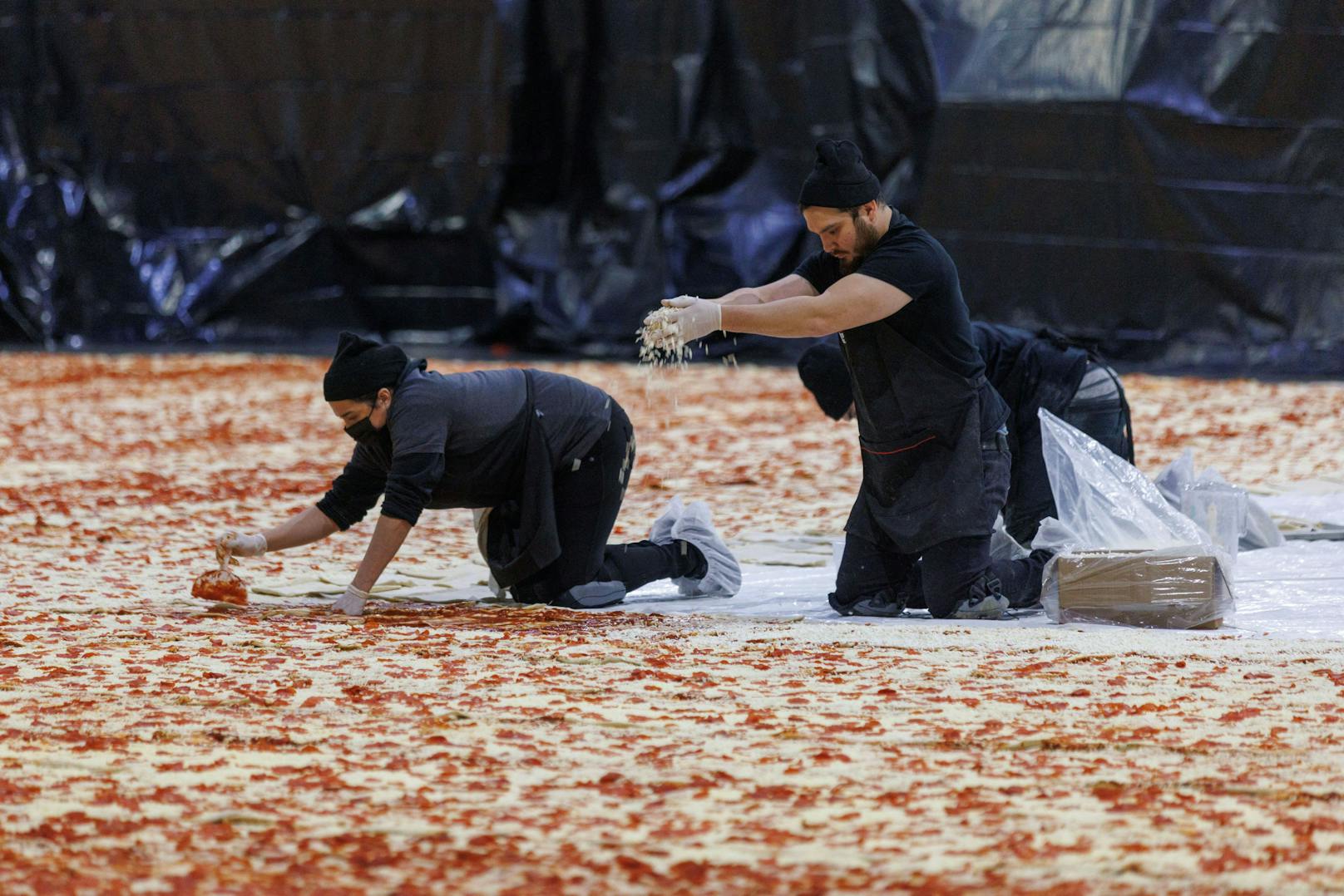 Zwei Tonnen Tomatensauce, über 600.000 Stück Pfefferoni, Unmengen Salami und fast vier Tonnen Käse wurden auf der Monsterpizza verteilt.