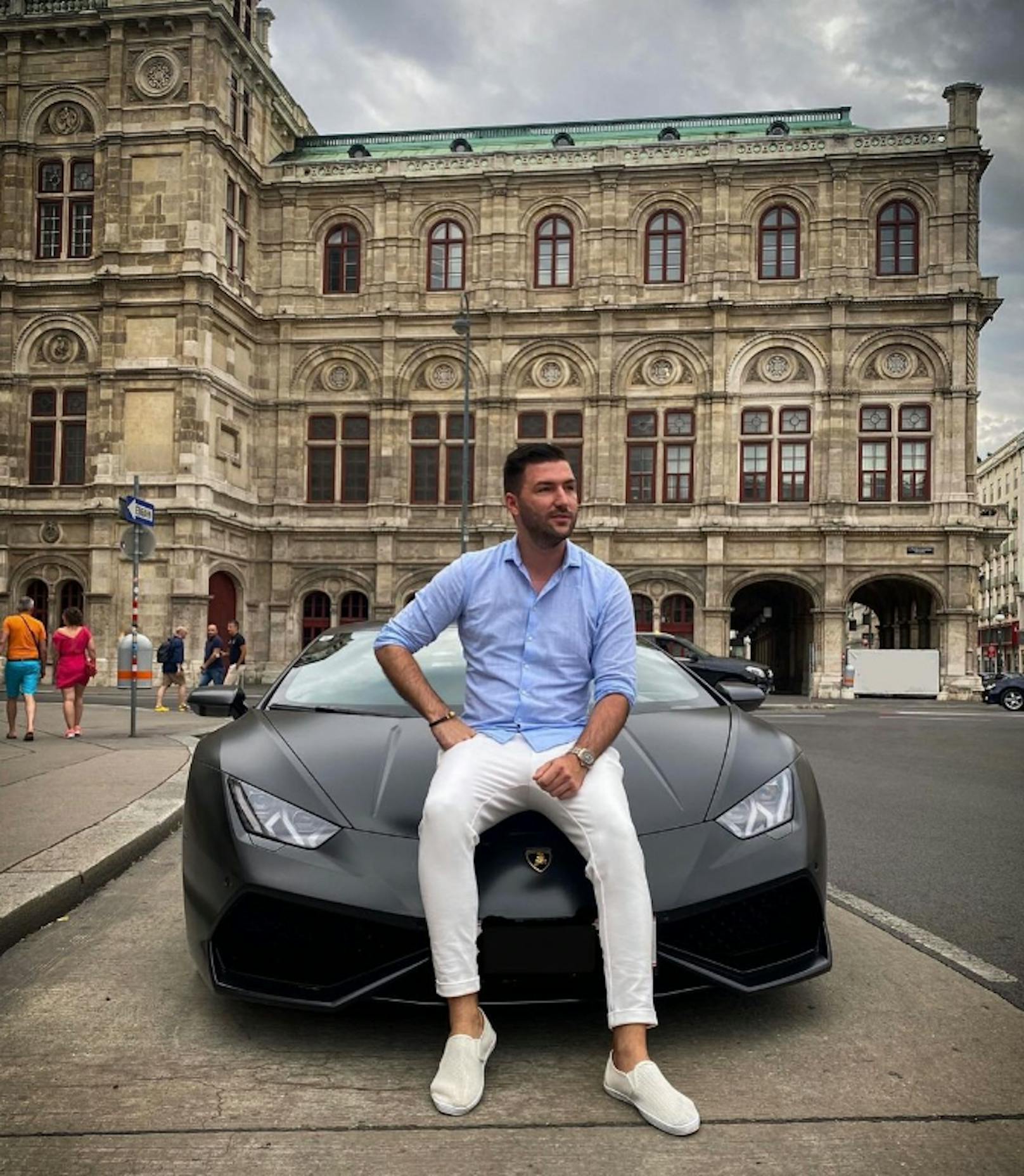 Stolz zeigt er sich im Lamborghini vor der Oper.