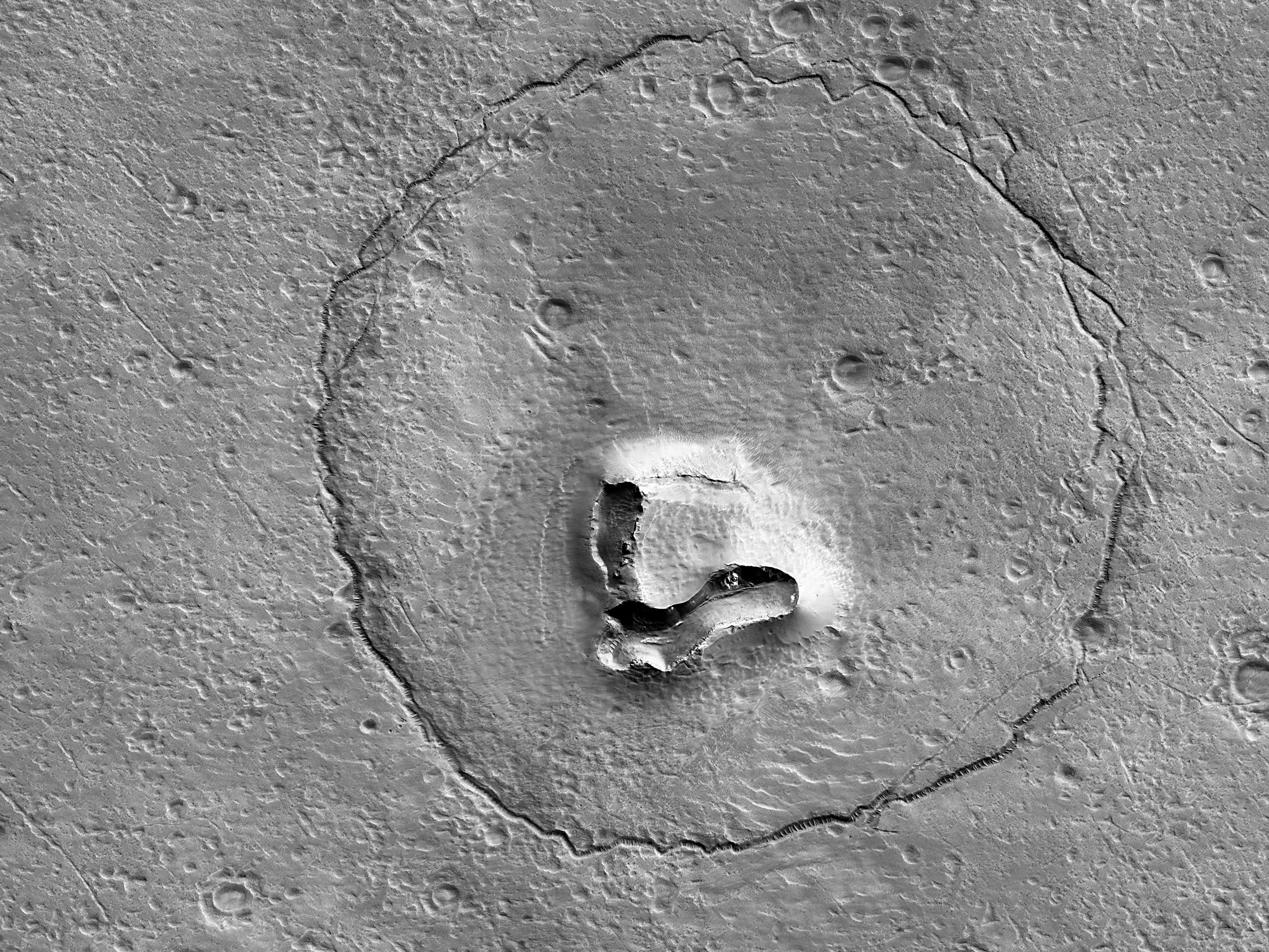 An undated image from NASA's Mars Reconnaissance Orbiter shows hills, craters and a circular fracture pattern on the surface of Mars, in this handout image obtained by Reuters on January 25, 2023. NASA/JPL-Caltech/UArizona/Handout via REUTERS - THIS IMAGE HAS BEEN SUPPLIED BY A THIRD PARTY. 