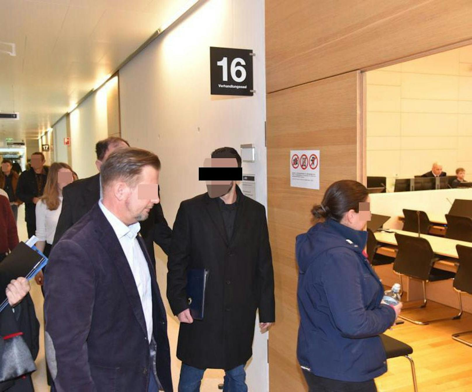 Der angeklagte Polizist (schwarzer Mantel) vor dem Gerichtssaal in Korneuburg: Es wurde ein glatter Freispruch.