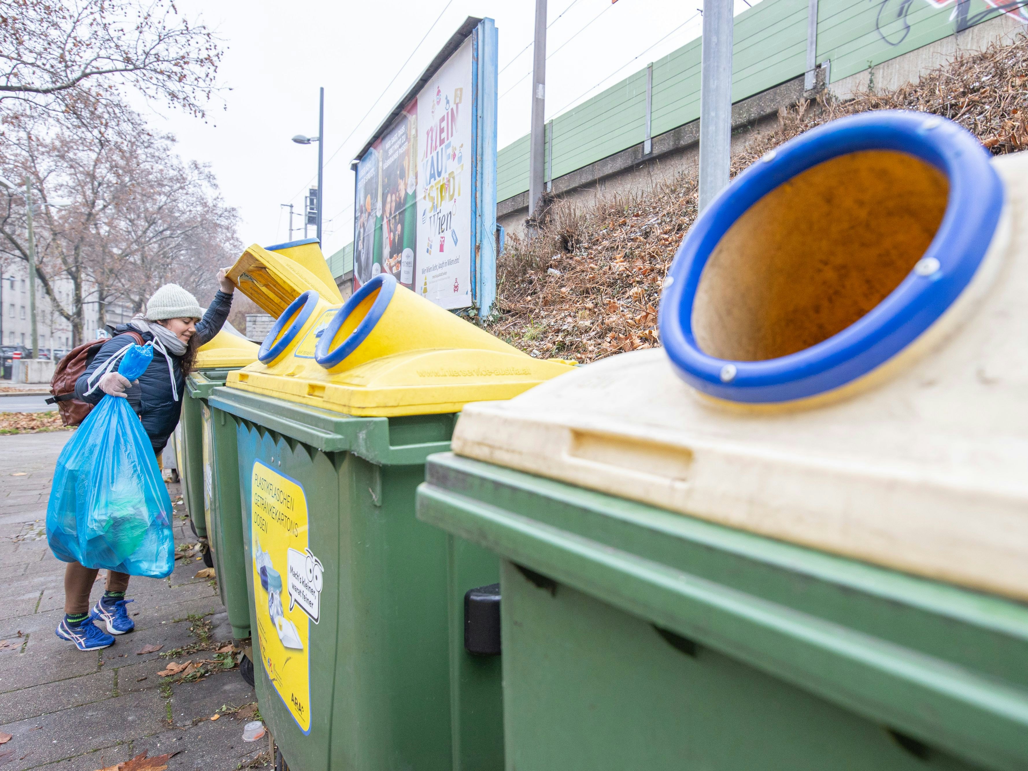 Download von www.picturedesk.com am 02.02.2023 (11:53).  In Österreich wird mit Jänner 2023 das Sammeln von Plastikmüll vereinheitlicht. Bisher gab es unterschiedliche Methoden in den Bundesländern. Wurde bisher teils unterschieden ob es sich um Flaschen, Getränkekartons oder Sackerl handelt, wandert von nun an alles Plastik in den gelben Sack oder die gelbe Tonne. Im Bild: Eine Frau steht mit einem Müllsack vor Plastikmüllcontainern. Wien, Österreich. 27.12.2022 // From January 2023 on, Austria is going to standardize the collection of plastic litter. Picture: Woman stands in front of plastic litter containers. Vienna, Austria. Dezemer 27th, 2022 - 20221227_PD2502 - Rechteinfo: Rights Managed (RM)