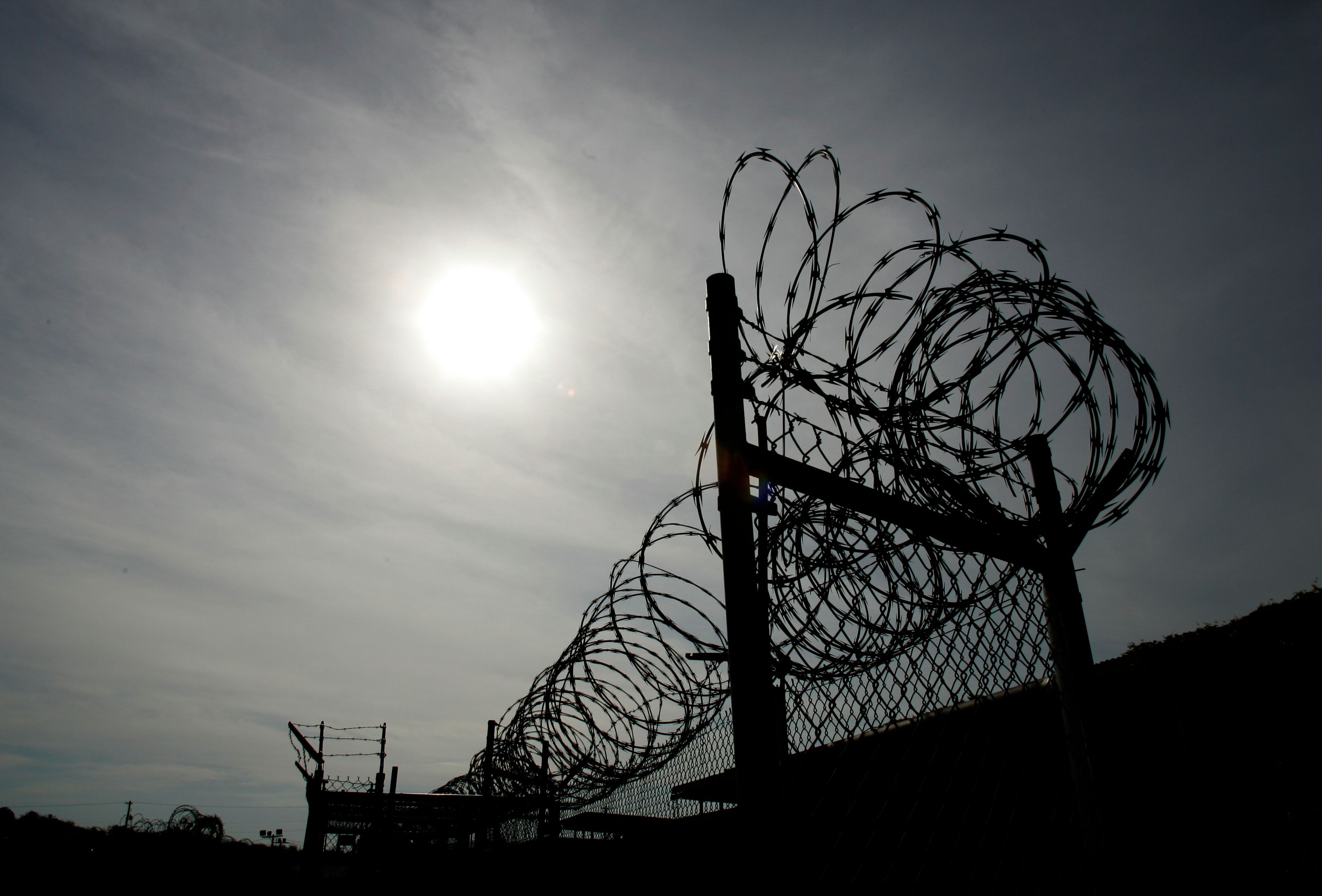 A rusting fence with barbed wire is shown at the unused Camp X-Ray at the Guantanamo Bay Naval Station in Guantanamo Bay, Cuba September 5, 2007. The first detainees in Guantanamo Bay were held for several months in the camp before being moved to Camp Delta. Picture taken September 5, 2007.  REUTERS/Joe Skipper     (CUBA)