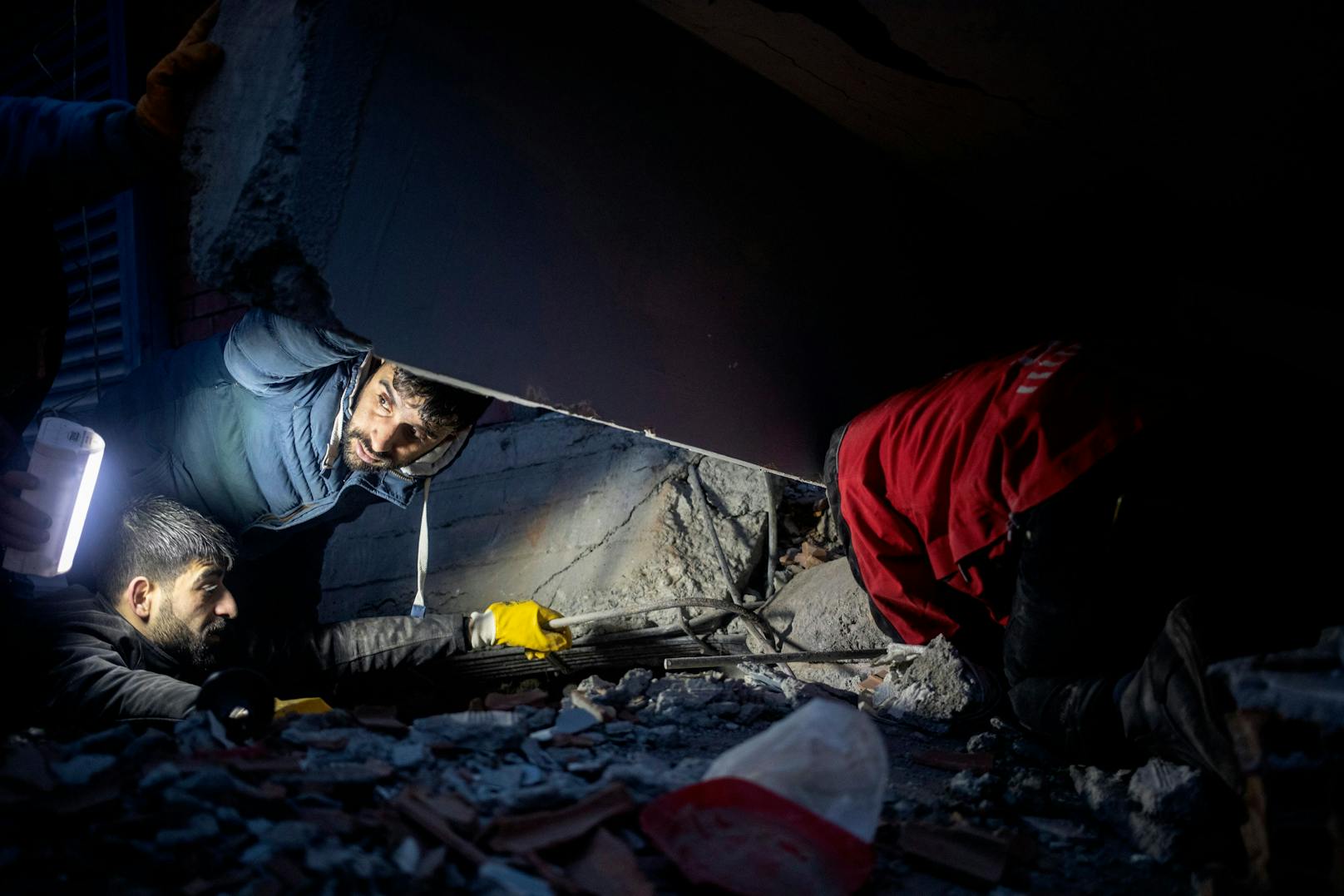 Menschen versuchen, den Opfern eines eingestürzten Gebäudes zu helfen.