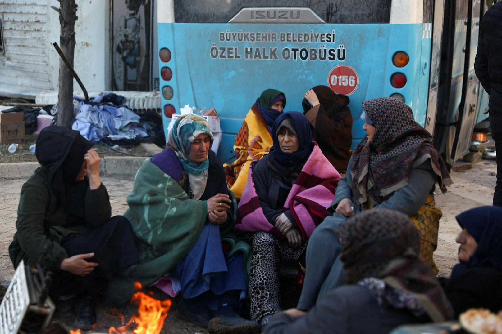 Die Frauen versuchen sich an einem Feuer zu wärmen.