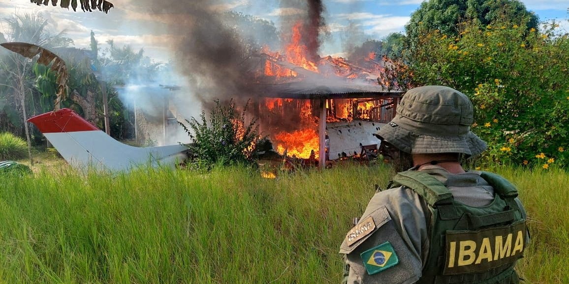 An agent of the Brazilian Institute for the Environment and Renewable Natural Resources (IBAMA), looks on as a plane and a house belonging to miners are destroyed during an operation conducted jointly within Brazil's National Indian Foundation (FUNAI) and Brazilian National Public Security Force against illegal mining in Yanomami indigenous land in Roraima state, Brazil February 6, 2023. IBAMA/Handout via REUTERS   ATTENTION EDITORS - THIS IMAGE HAS BEEN SUPPLIED BY A THIRD PARTY. NO RESALES. NO ARCHIVES