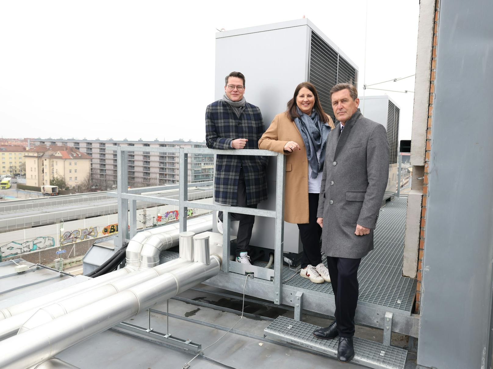 Klimastadtrat Jürgen Czernohorszky, Wohnbaustadträtin Kathrin Gaál und Finanz- und Wirtschaftsstadtrat Peter Hanke am Dach der Wohnanlage, wo zwei Wärmepumpen installiert wurden.