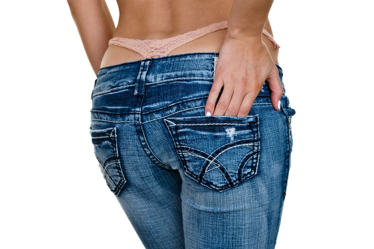 Female buttocks wearing jeans with thong coming out 