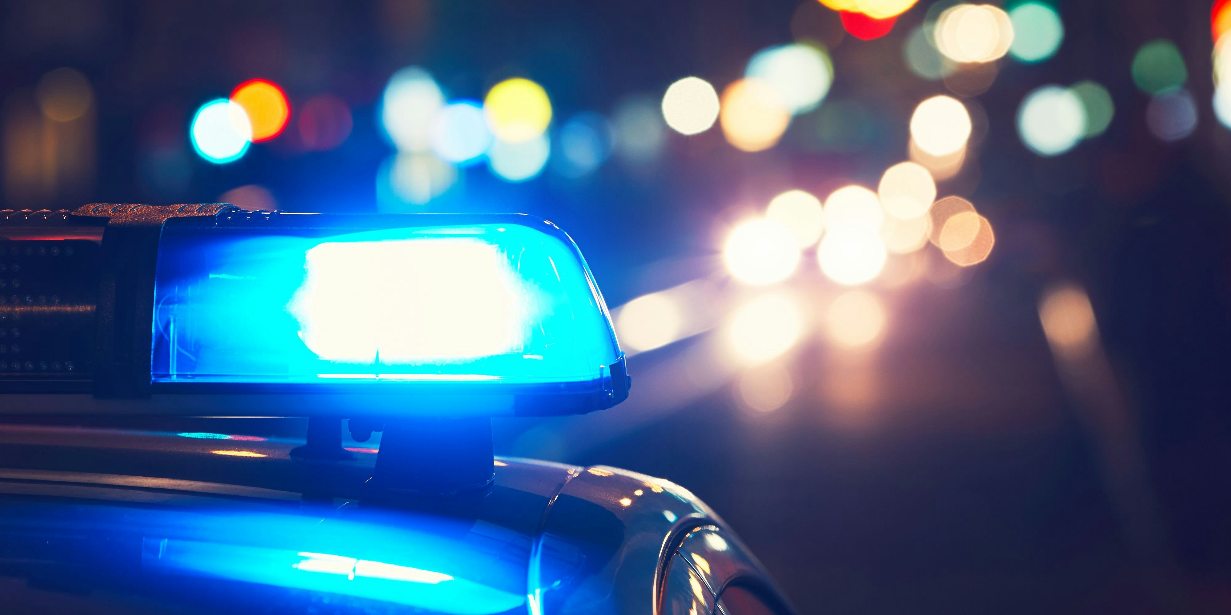 Danger on the road. Blue flasher on the police car at night.