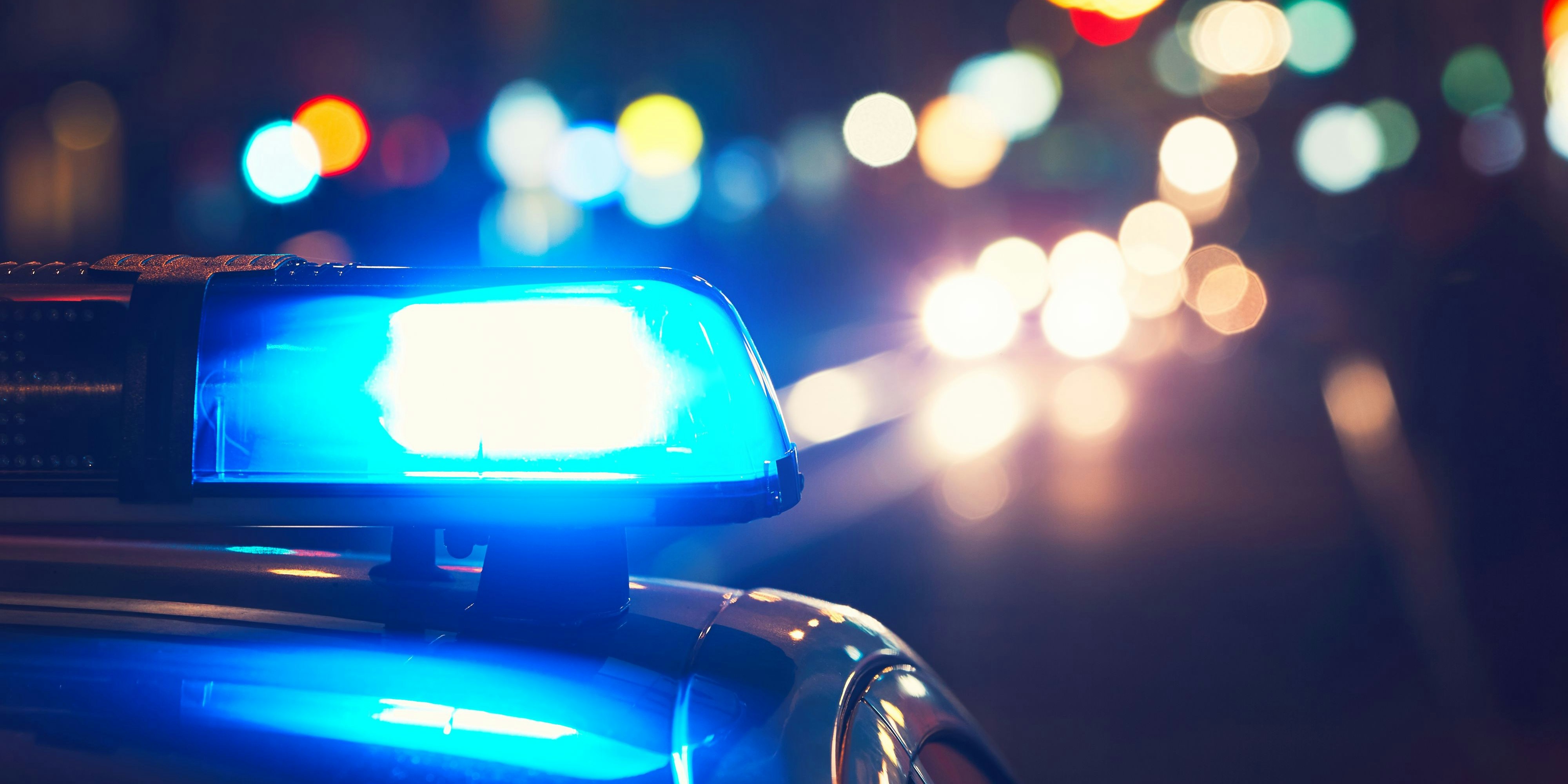 Danger on the road. Blue flasher on the police car at night.