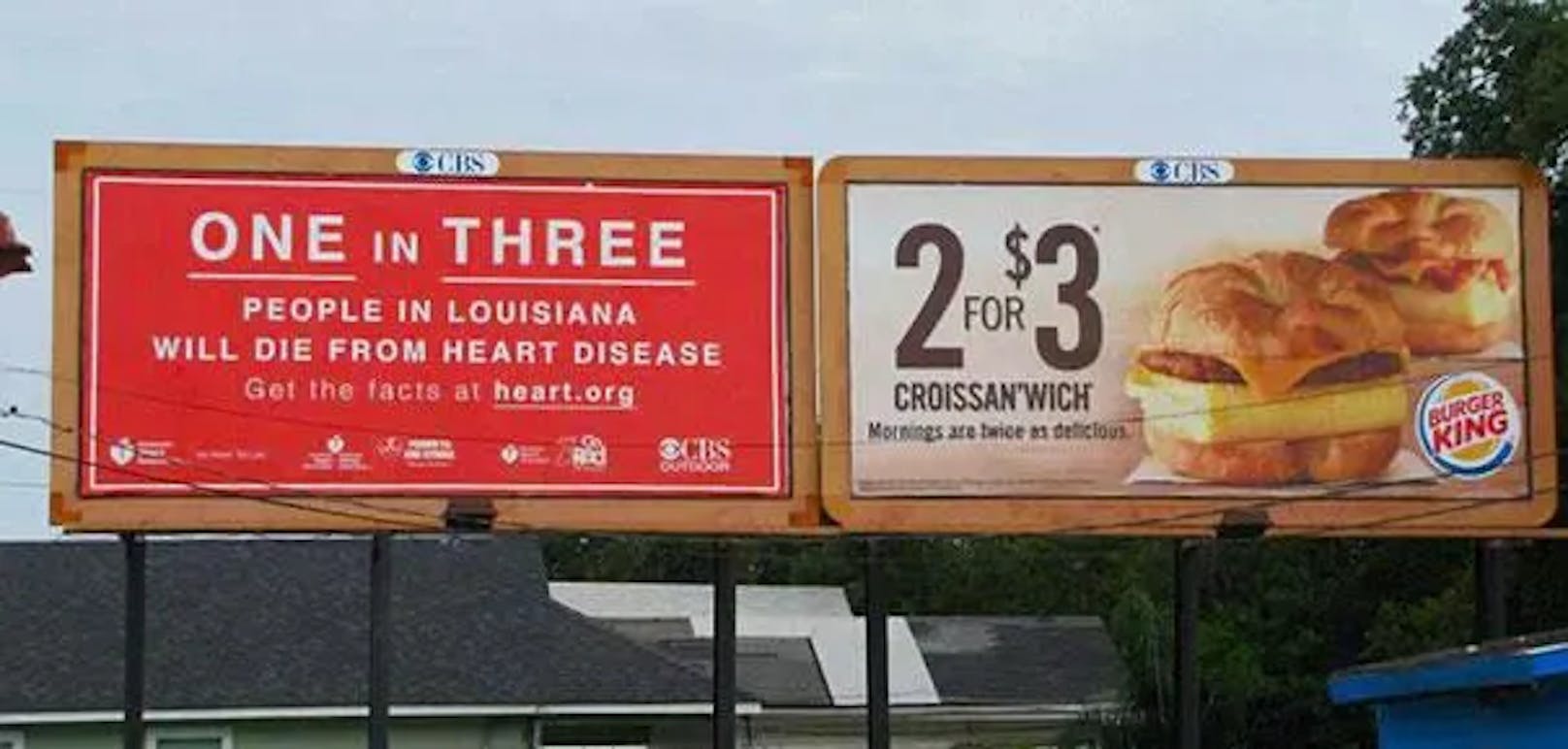 "Eine von drei Personen im US-Bundesstaat Louisiana stirbt an einer Herzerkrankung", vermeldet die Werbetafel links. Direkt daneben wird für besonders günstige Sandwiches von Burger King geworben: Zwei dieser Kalorienbomben kosten nur drei Dollar.