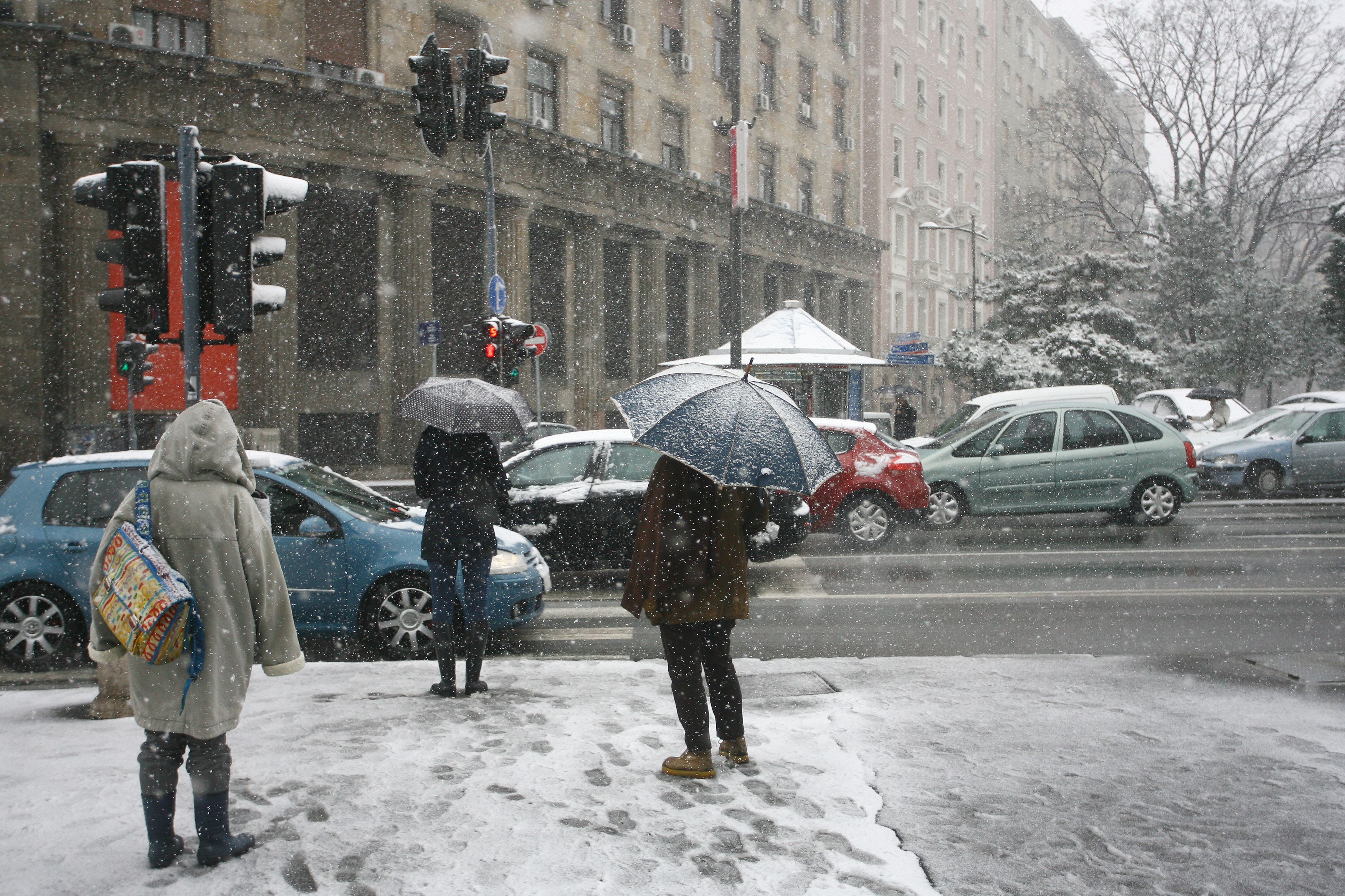 Passanten bei Schneefall in einer Stadt. Symbolbild