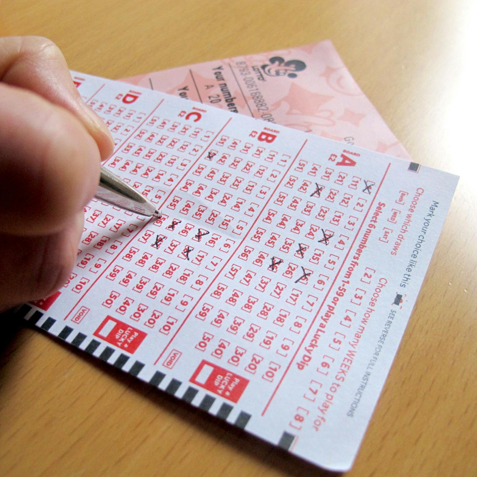 Eine Frau beim Ausfüllen eines britischen Lottoscheins. Symbolbild