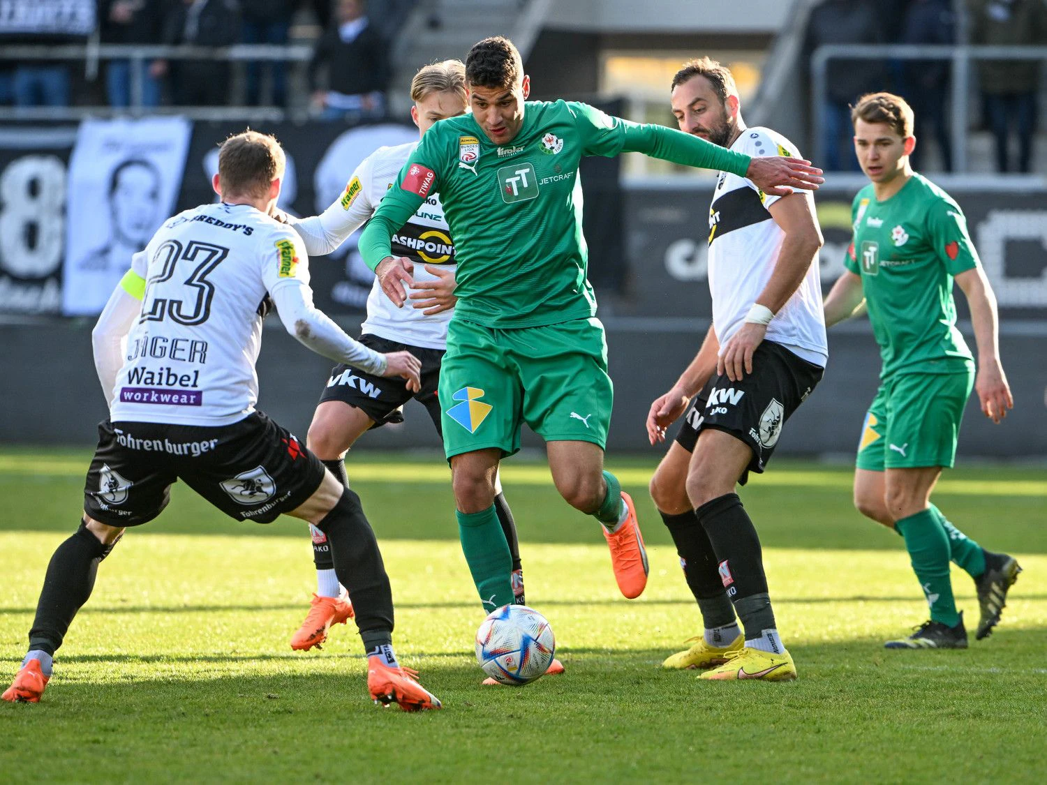 Raffael Behounek von Altach-Profis umringt.