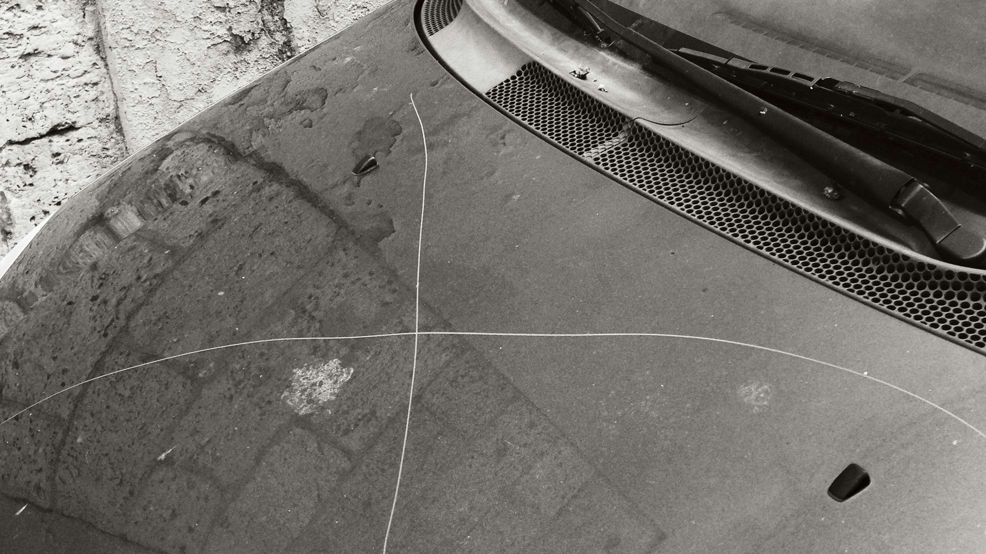 Pisa, Italy. A large "X" was scratched on the bonnet of this car parked in the public street. iPhone 5