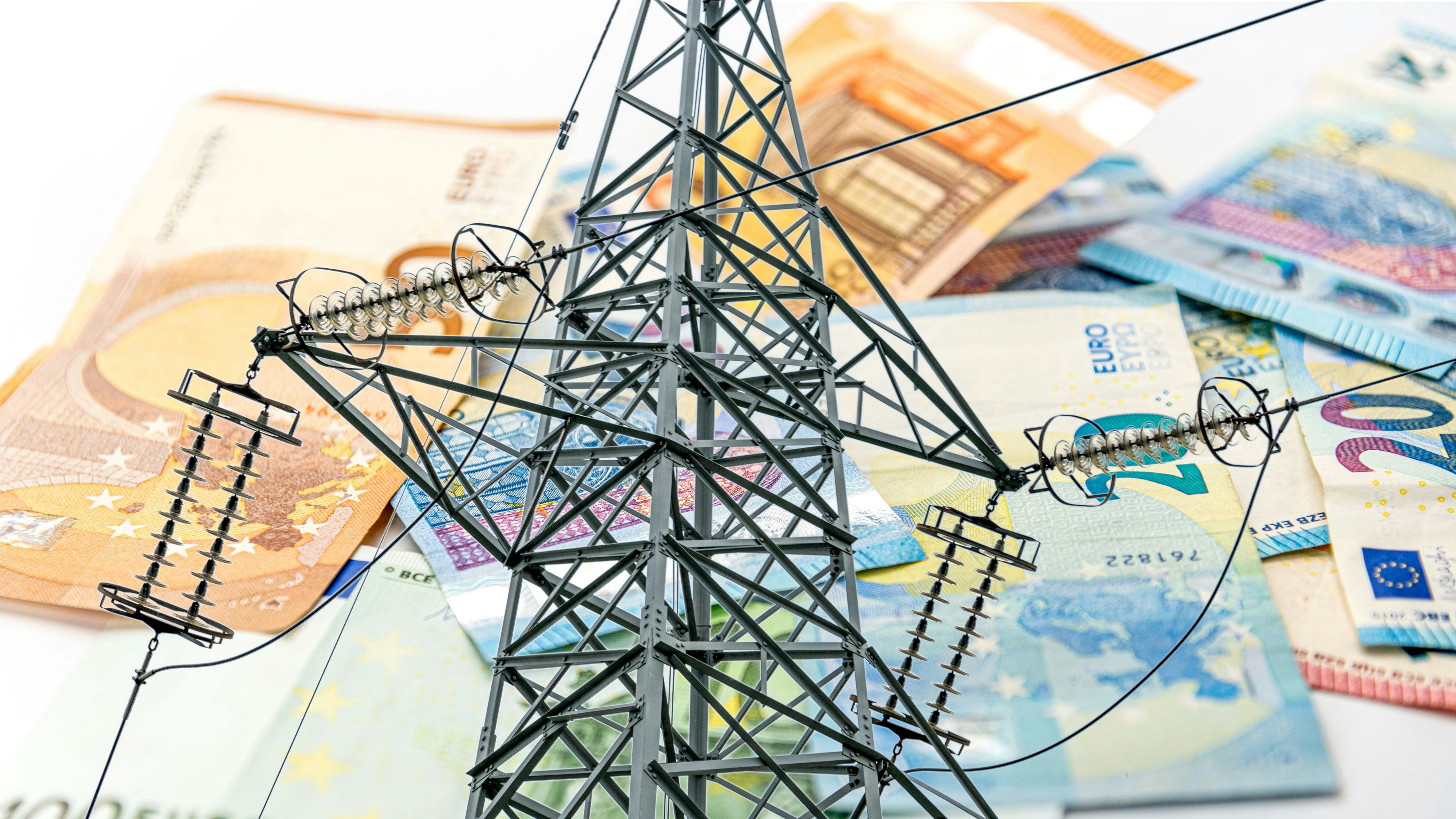 Electric tower and euro money, high voltage electric pylon on euro banknotes in selective focus, energy cost concept