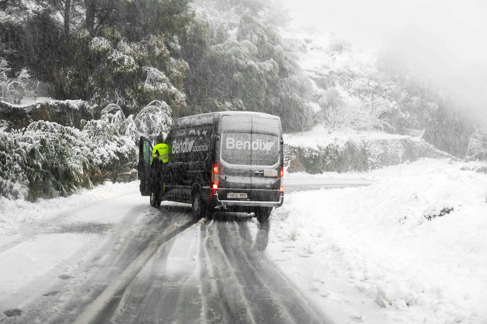 Ein Lieferwagen kommt auf einer schneebedeckten Straße in der Nähe des Bergdorfs Valldemossa ins Schleudern.