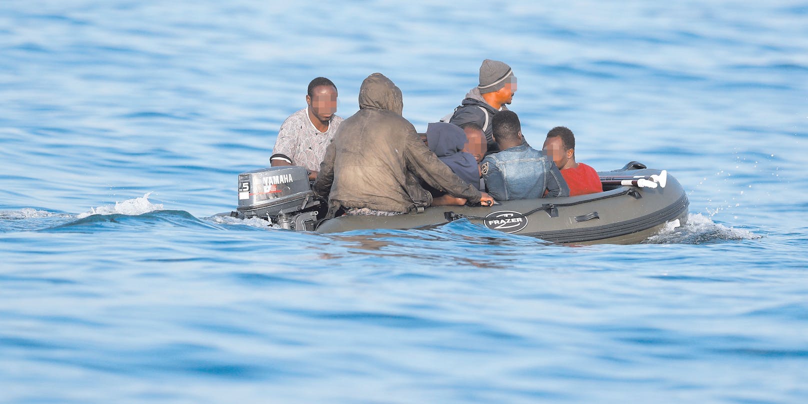 Migranten am Schlauchboot.