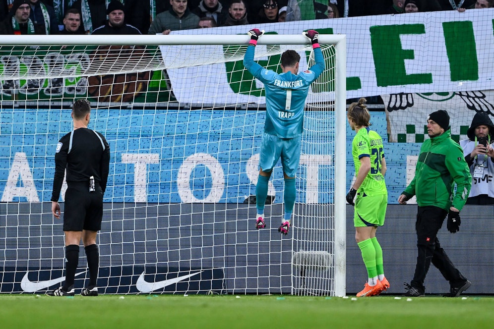 Frankfurt-Keeper Trapp hängt an der Torstange, um das Tor zu reparieren. 