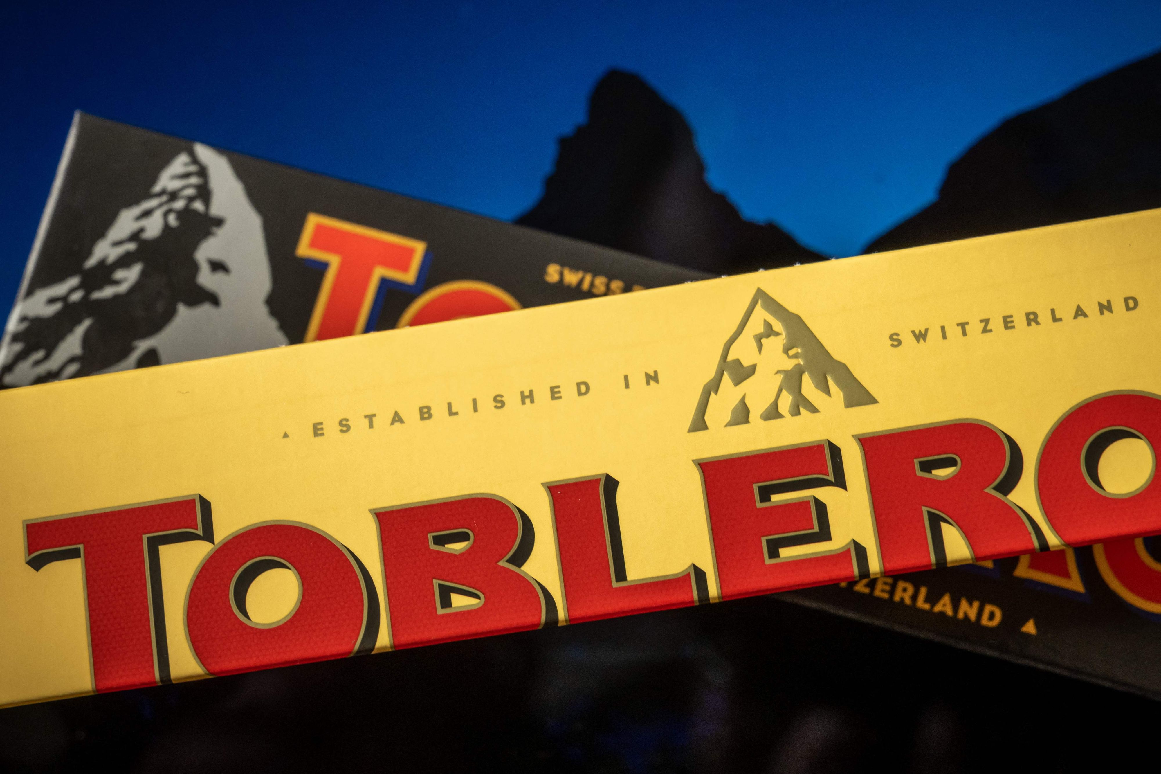 Download von www.picturedesk.com am 07.03.2023 (12:59).  A picture taken on March 6, 2023, shows packagings of Toblerone chocolate bars owned by US firm Mondelez with a representation of the Matterhorn mountain (back) and of a generic mountain (front) in Geneva. - Toblerone is to remove the Swiss iconic Matterhorn peak from its packaging when some of the chocolate's production is moved from Switzerland to Slovakia and replaced by a more generic mountain under strict "Swissness" rules. (Photo by Fabrice COFFRINI / AFP) - 20230306_PD2923 - Rechteinfo: Rights Managed (RM) Nur für redaktionelle Nutzung! Werbliche Nutzung erfordert Freigabe: bitte schicken Sie uns eine Anfrage.