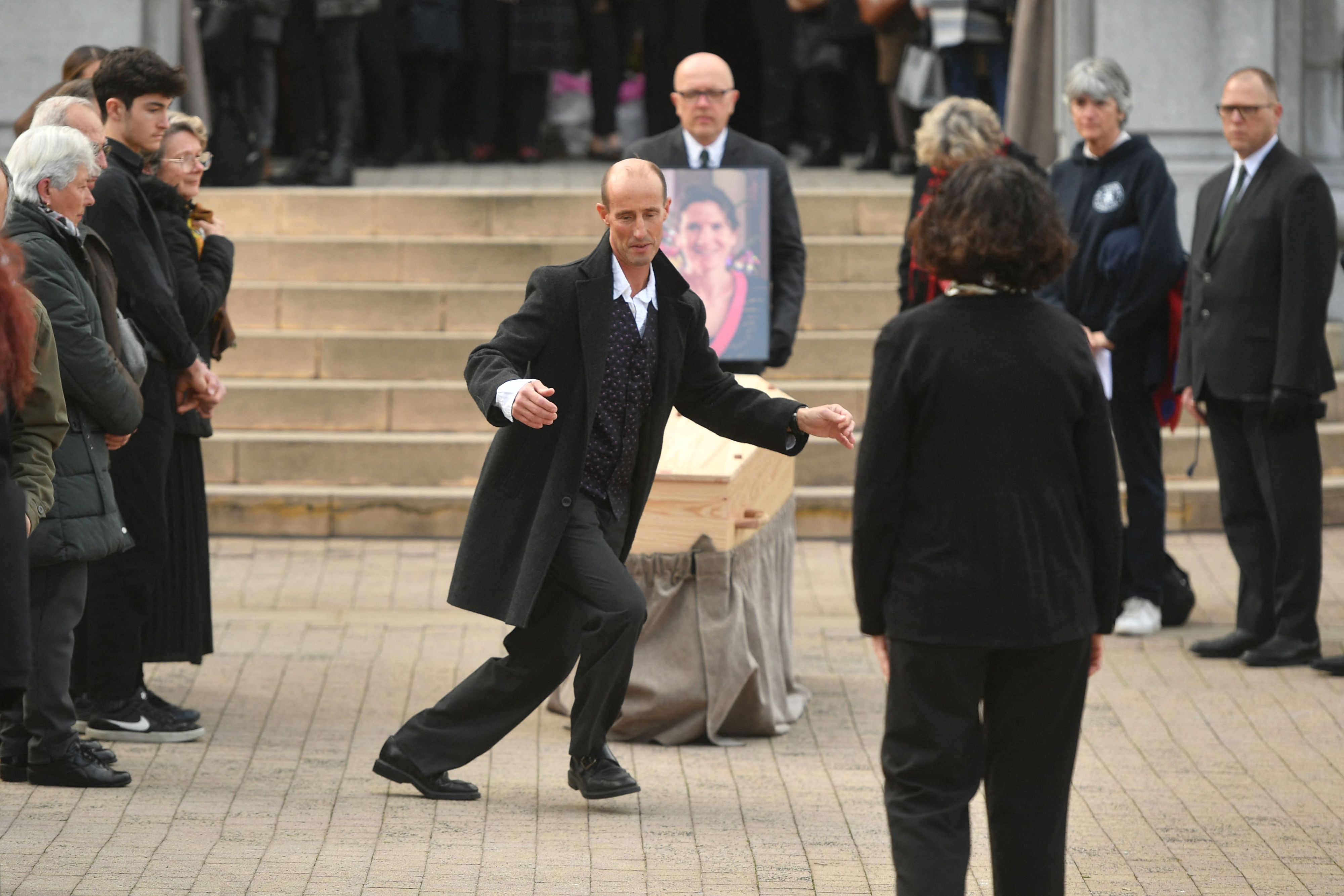 Agnes Lassalle's partner Stephane Voirin dances near the coffin during the funeral ceremony of French teacher Agnes Lassalle at the Sainte-Eugenie church in Biarritz, southwestern France, on March 3, 2023.