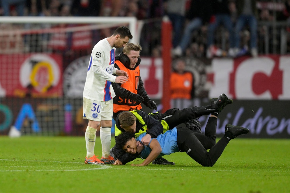 Ordner müssen Lionel Messi vor dem Flitzer schützen.