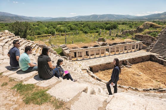 Ein Reiseführer und seine Gruppe in der antiken Stadt Aphrodisias in der Türkei: Tausend Jahre lebendige Geschichte verständlich zu vermitteln, gehört zu einer der Aufgaben eines Reiseführers.