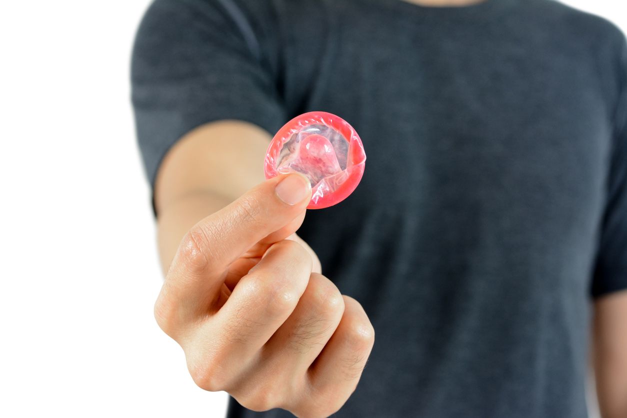 Young man giving condom, sexaul transmitted disease protection concept