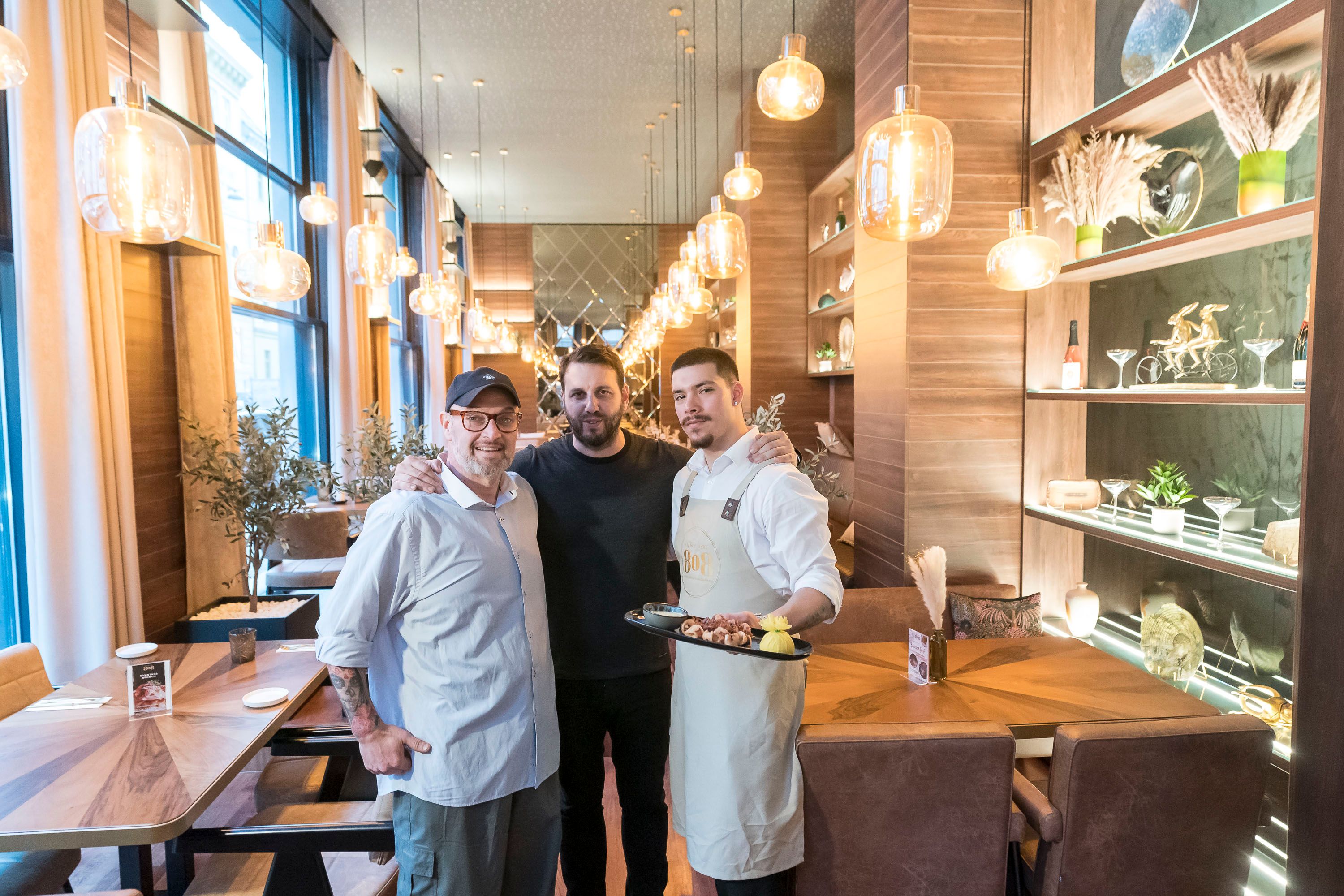 Michael (Frühstückskoch), Mile (Eigentümer) und Adrian (Bar und Service) mit gegrilltem Oktopus (v.l.)