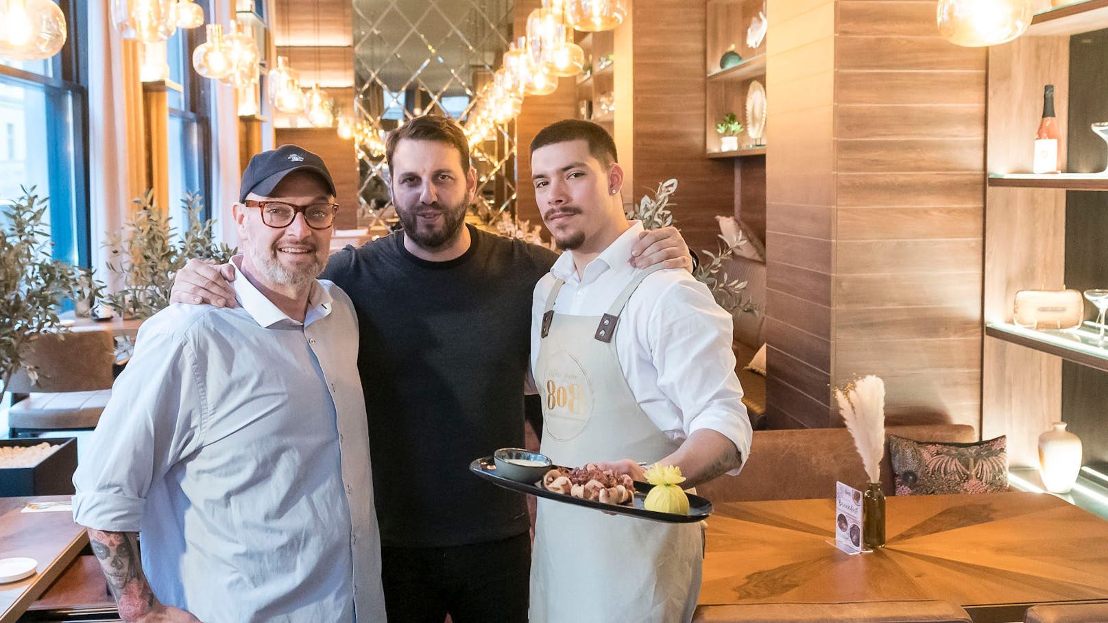Michael (Frühstückskoch), Mile (Eigentümer) und Adrian (Bar und Service) mit gegrilltem Oktopus (v.l.)