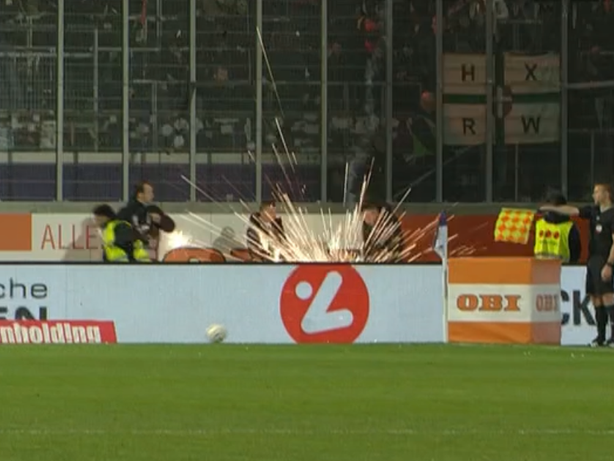 Pyrotechnik aus dem Auswärtssektor landet neben Ordnern.