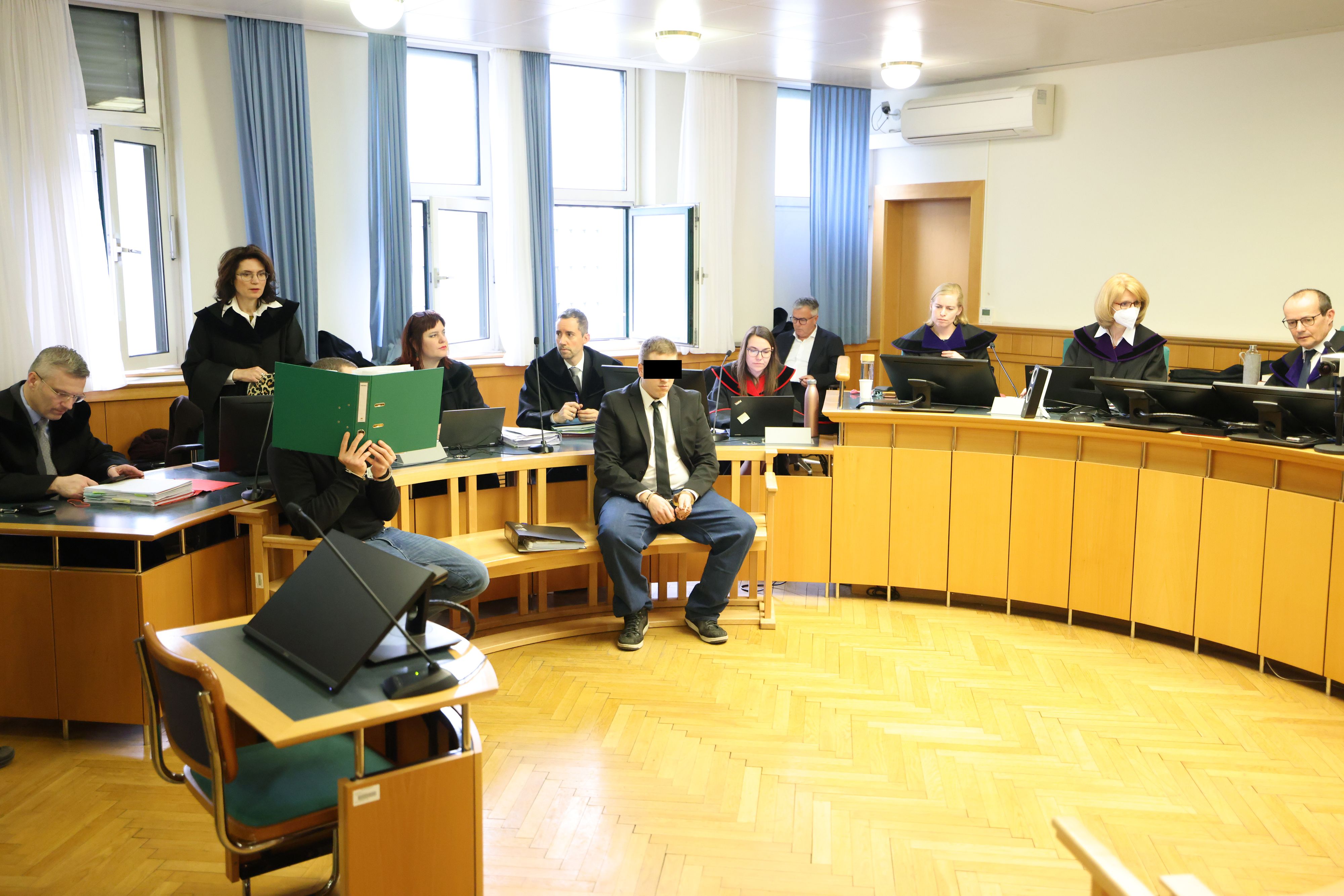 Die beiden Angeklagten am Tag der Urteilsverkündung im Gerichtssaal, dahinter die Verteidiger Astrid Wagner (stehend) und Manfred Arbacher-Stöger (l.)